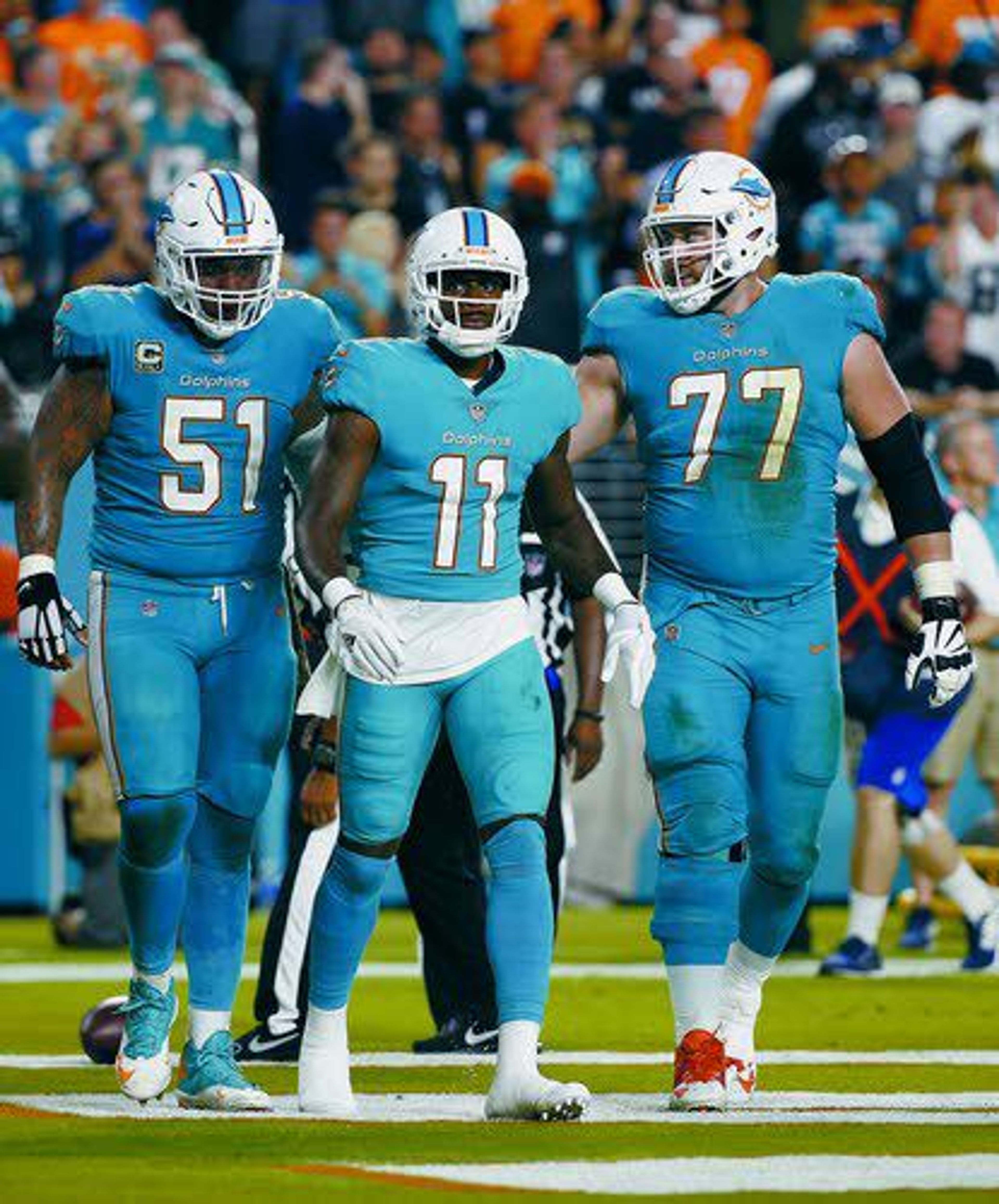 Miami wide receiver DeVante Parker (middle), center Mike Pouncey (left) and offensive guard Jesse Davis walk together earlier this season during a game.