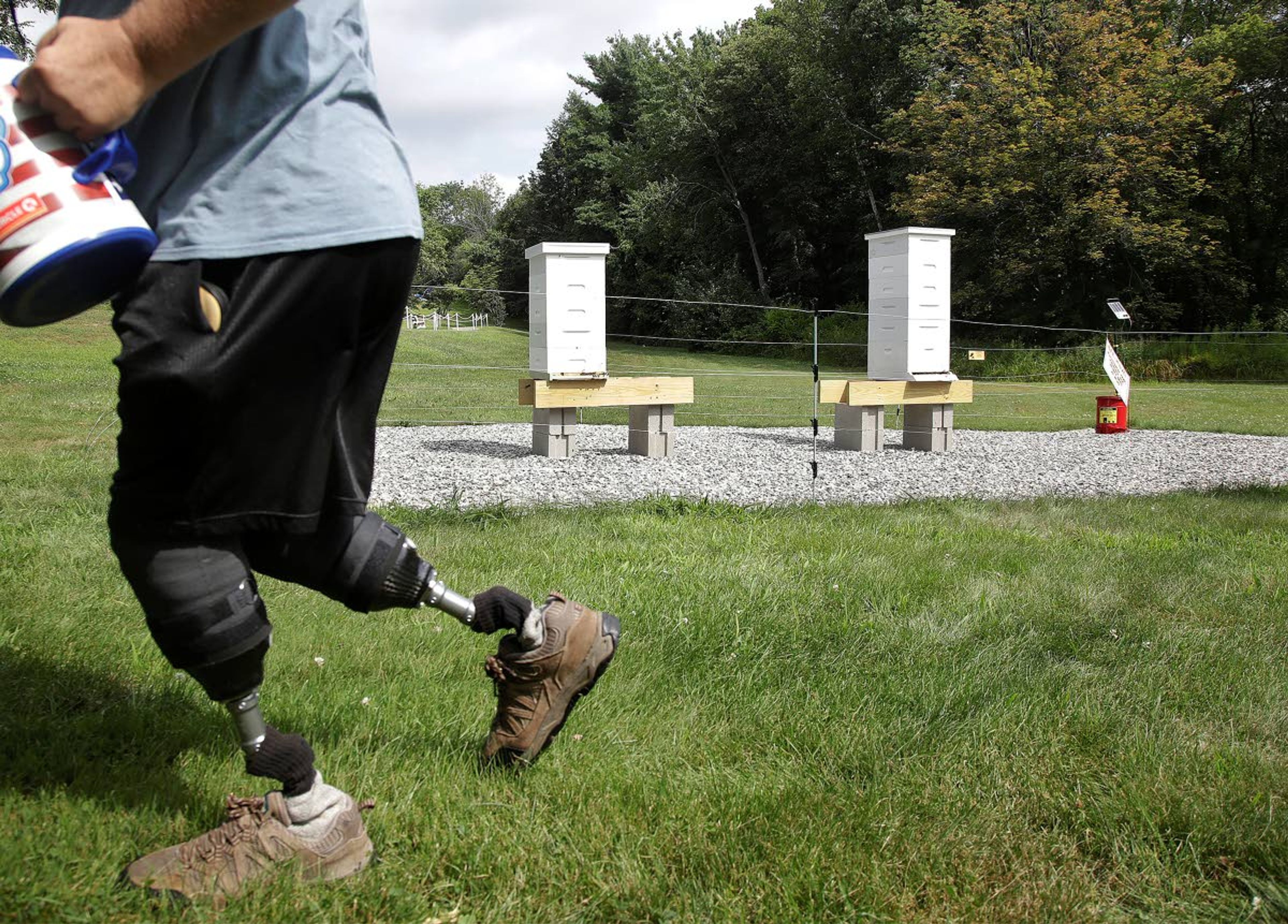 In this Aug. 7, 2019 photo, U.S. Army veteran Oscar Toce cleans up after beekeeping at the Veterans Affairs' beehives in Manchester, N.H. Veterans Affairs has begun offering beekeeping at a few facilities including in New Hampshire and Michigan, and researchers are starting to study whether the practice has therapeutic benefits. (AP Photo/Elise Amendola)