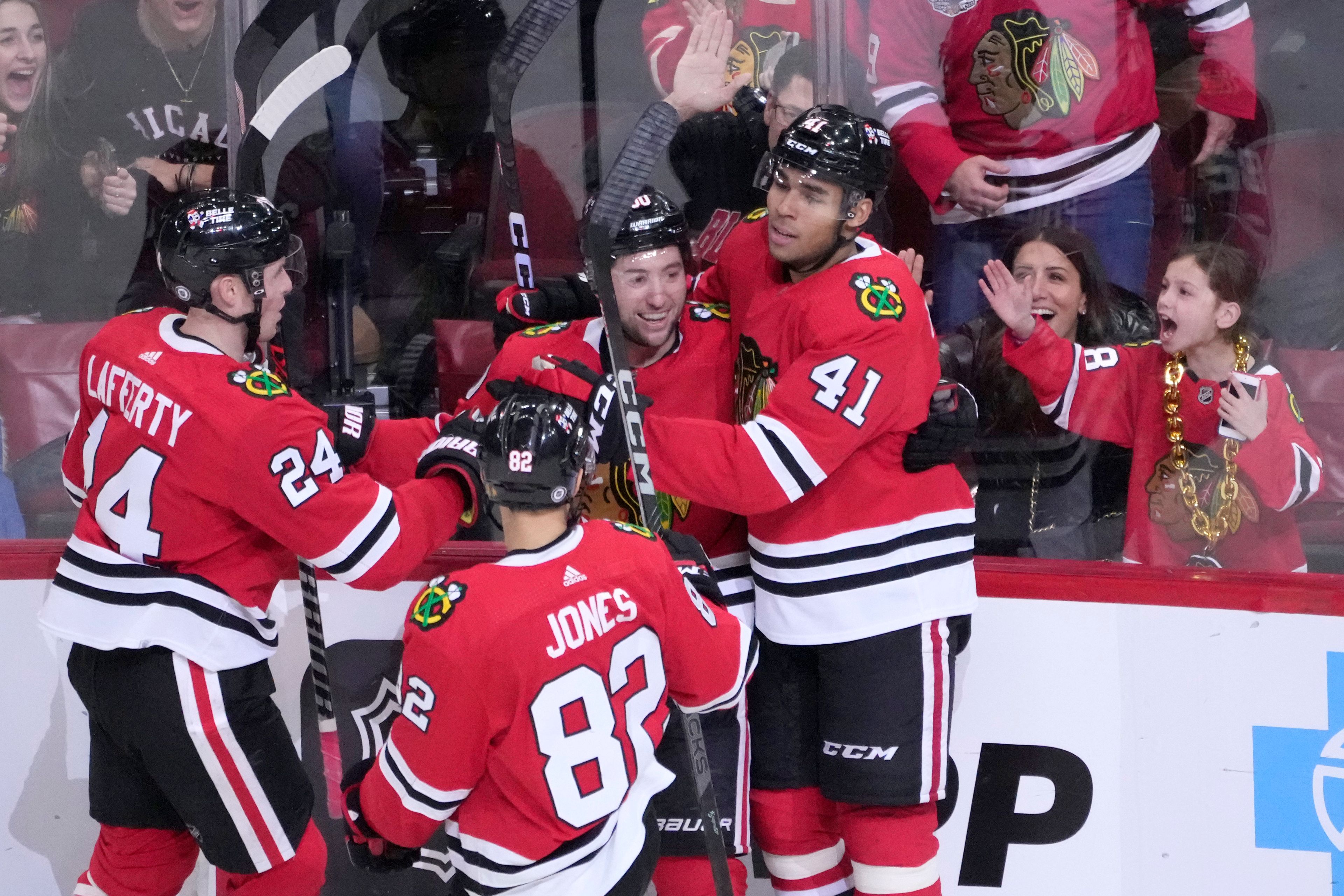 Chicago Blackhawks' Isaak Phillips (41) celebrates his first career NHL goal with Sam Lafferty (24) Caleb Jones (82) and Tyler Johnson during the second period of a hockey game against the Seattle Kraken, Saturday, Jan. 14, 2023, in Chicago. (AP Photo/Charles Rex Arbogast)