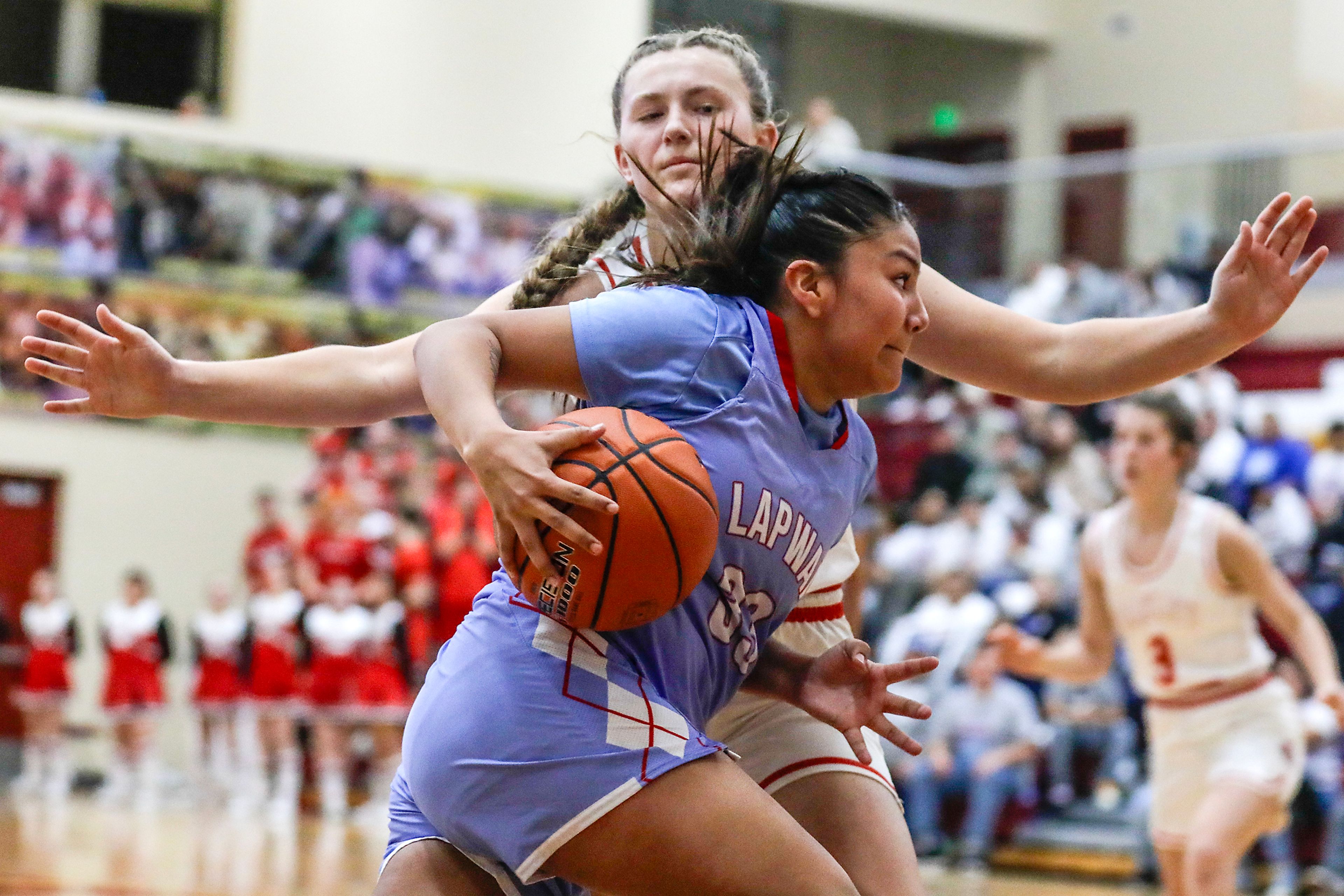 Lapwai's Madden Bisbee runs around Oakley guard Taylin Beck during an Idaho Class 1A DI girls state semifinal game Friday at Columbia High School.