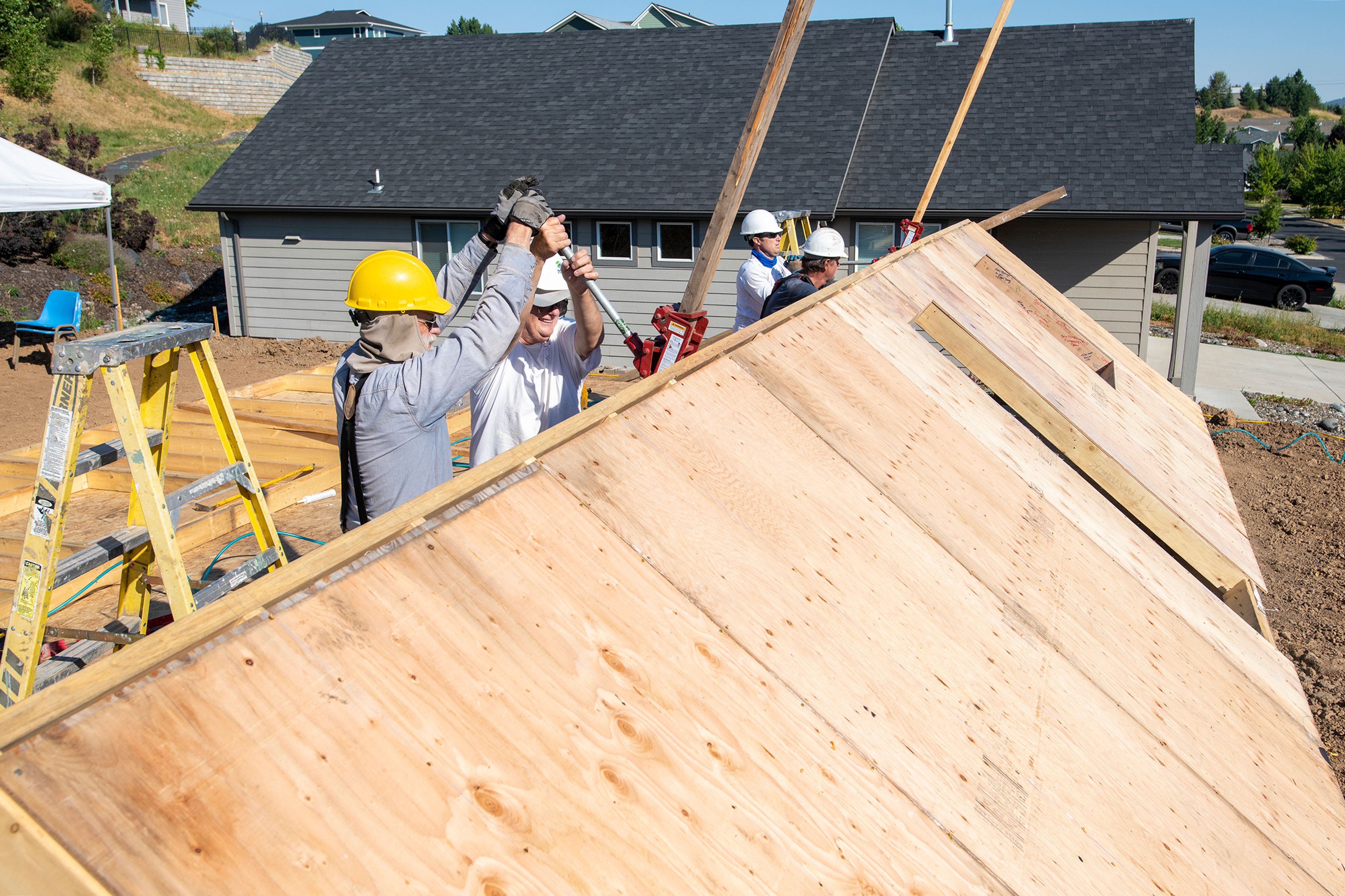 Volunteers from Palouse Habitat for Humanity raise a wall for a home being constructed on Leepike Court in Moscow.