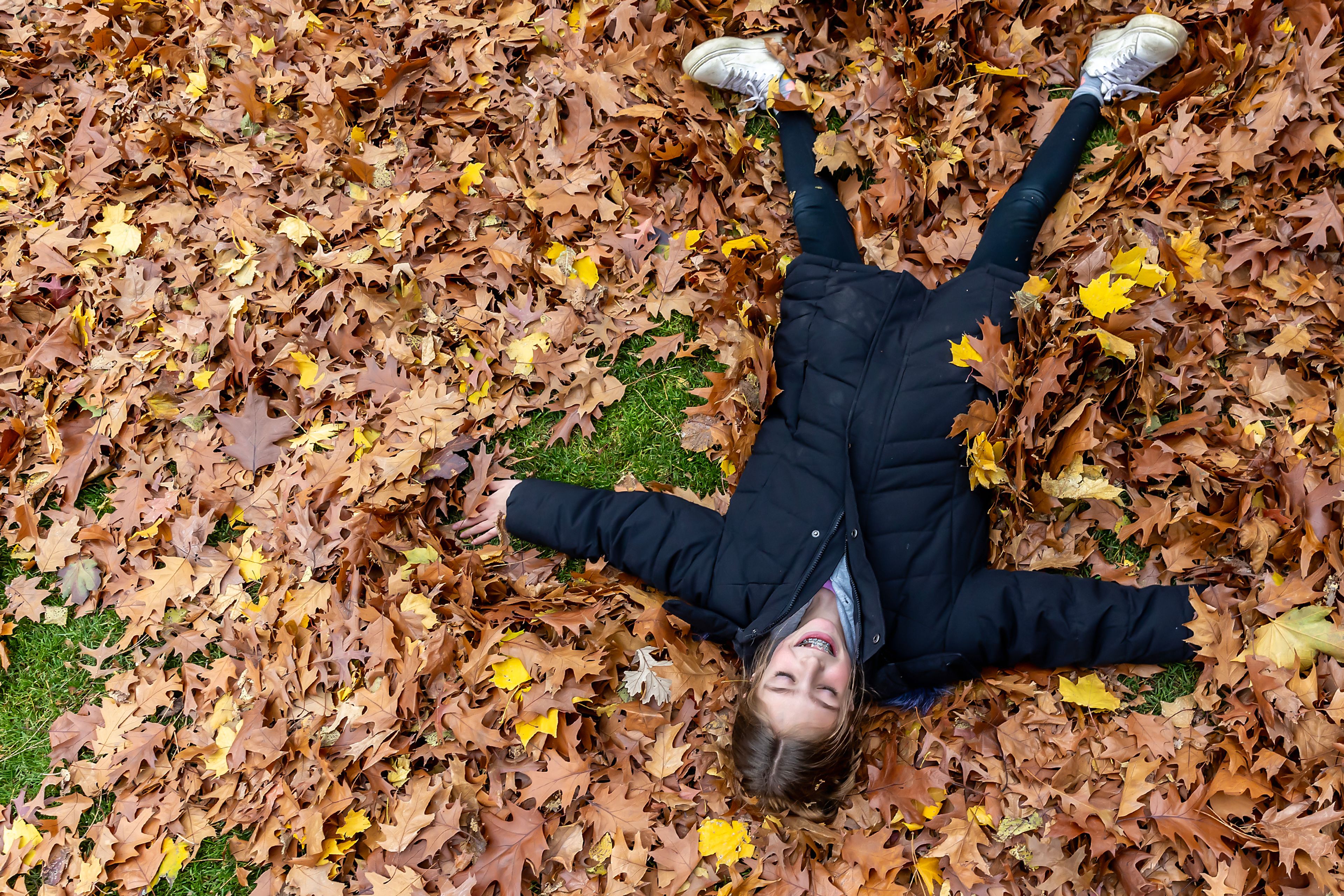 Isabelle Bancroft makes a leaf angle in a pile outside Children's House Montessori School at Pioneer Park Wednesday in Lewiston.