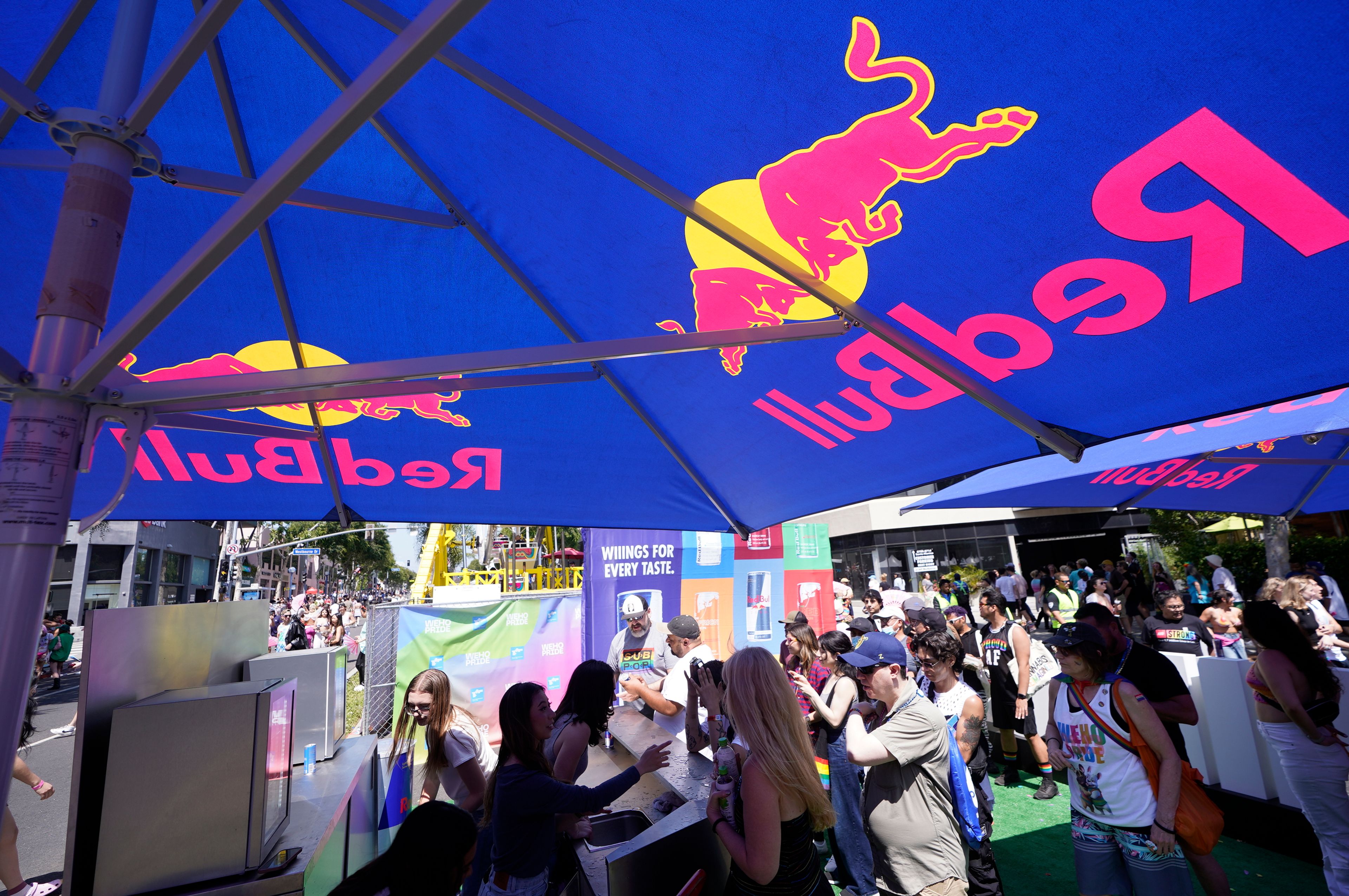 People line up for free Red Bull Energy Drinks at the WeHo Pride Parade in West Hollywood, Calif., on Sunday, June 4, 2023. (AP Photo/Damian Dovarganes)