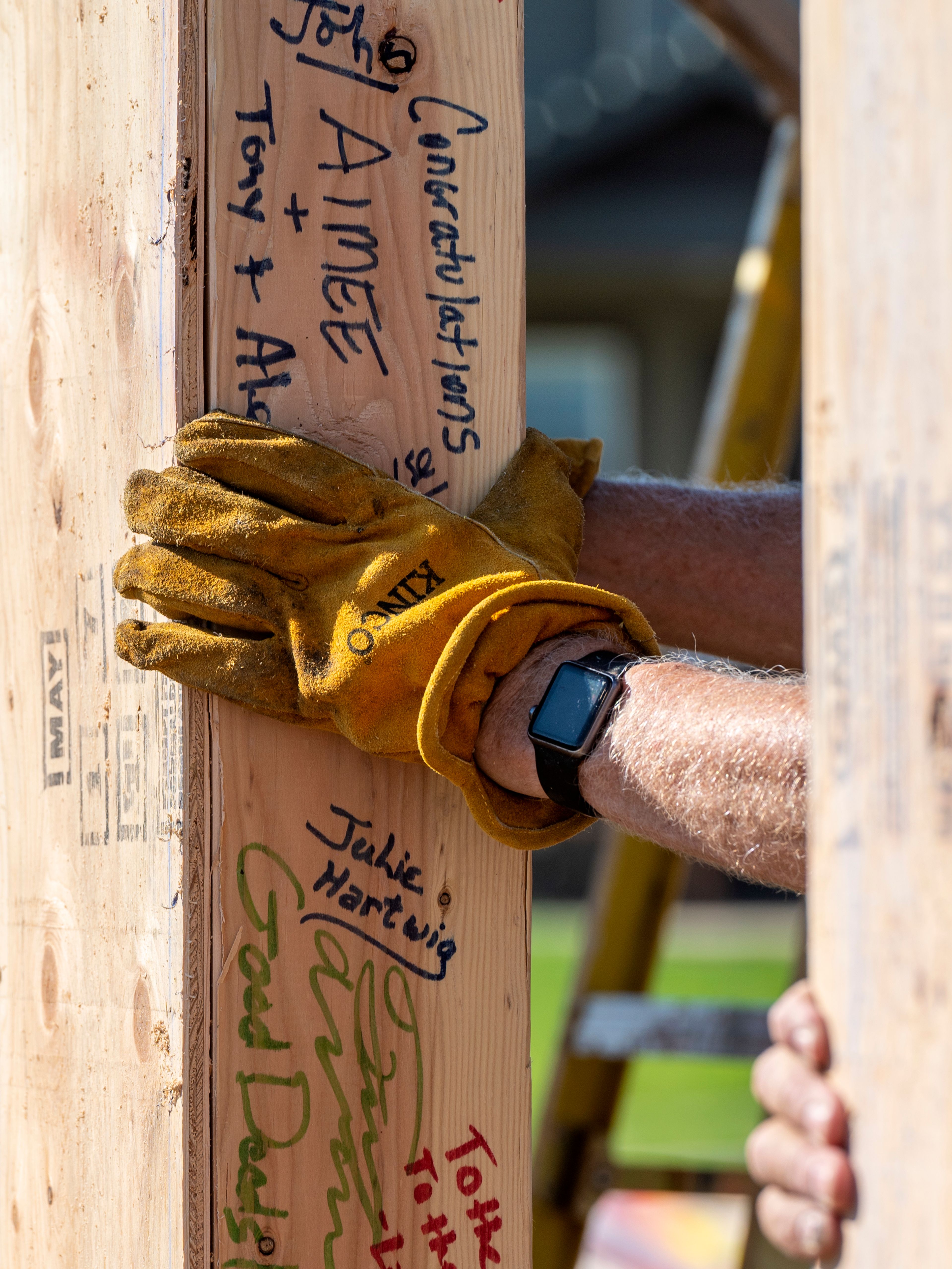 A volunteer's hand covers a wood frame that has been signed by numerous people in honor of the home being constructed by volunteers of Palouse Habitat for Humanity on Leepike Court in Moscow.