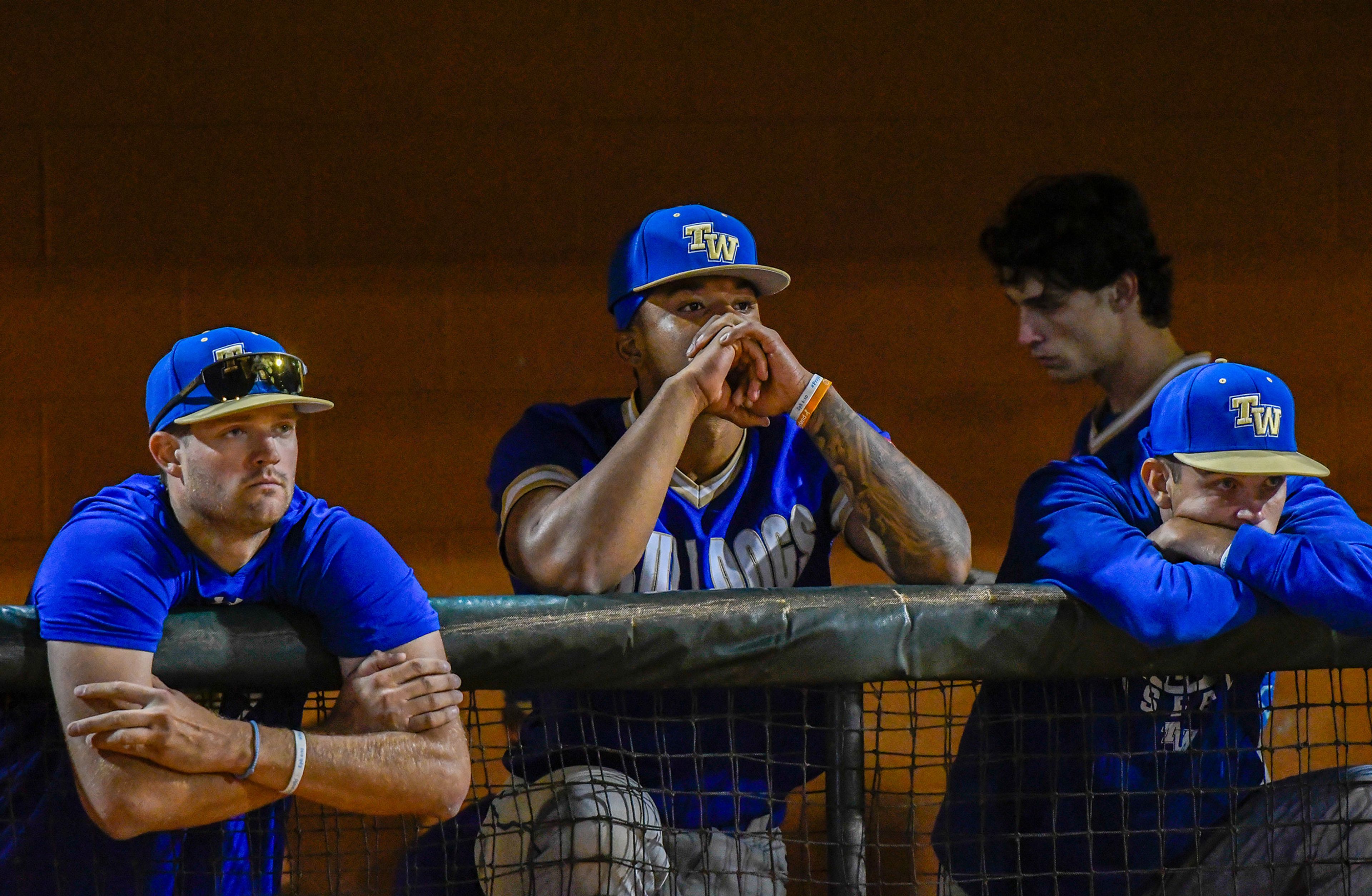 Tennessee Wesleyan team members react to their loss as Hope International takes to the field to celebrate their championship win in the NAIA World Series at Harris Field in Lewiston on Friday.