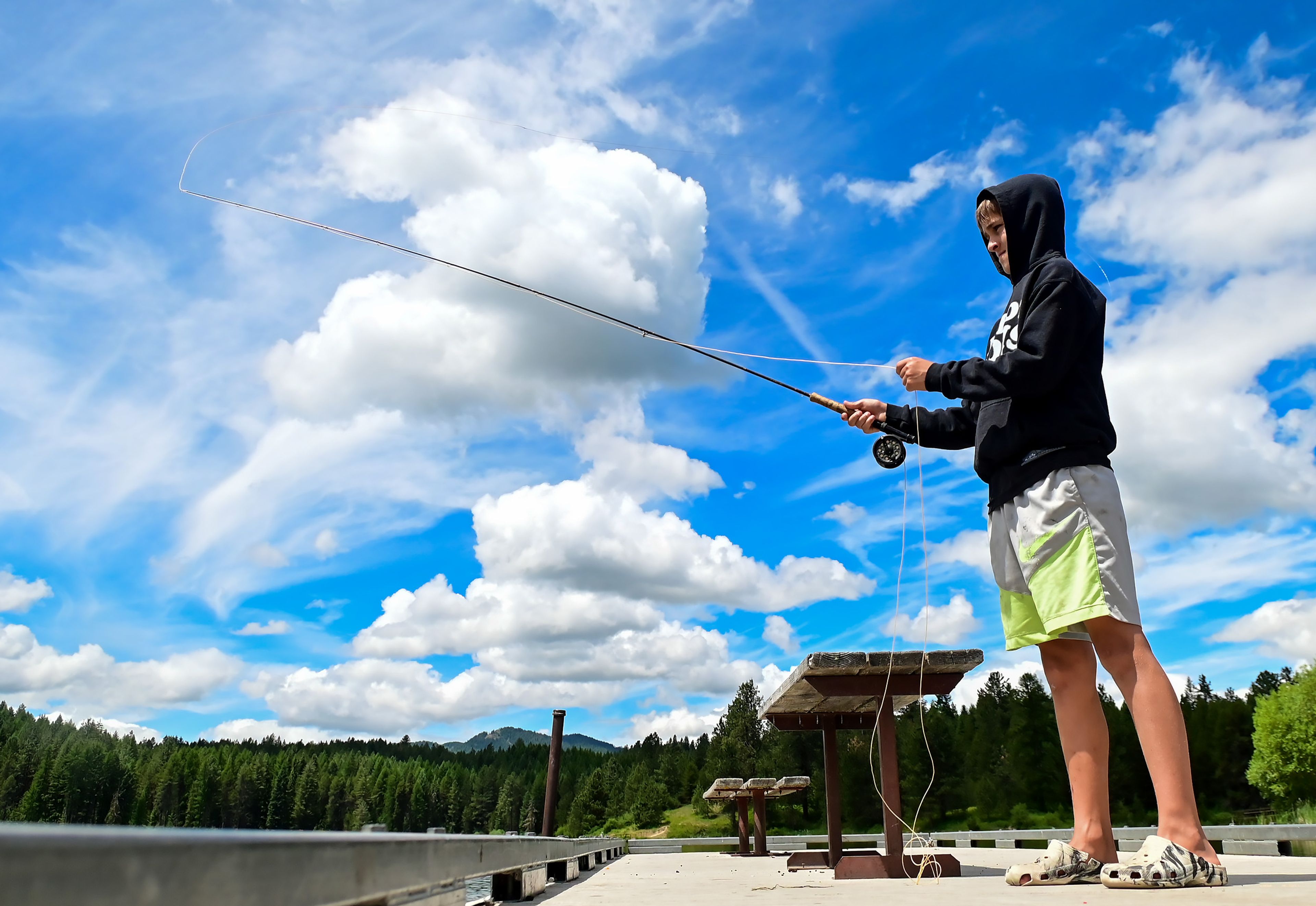 Dominik Burton, 12, of Chicago, flicks the fly line over his head while trying his hand at fly fishing at the Spring Valley Reservoir outside of Troy on Friday. Burton’s aunt Robin Barnes, of Moscow, gives tips and instructions off to the side.