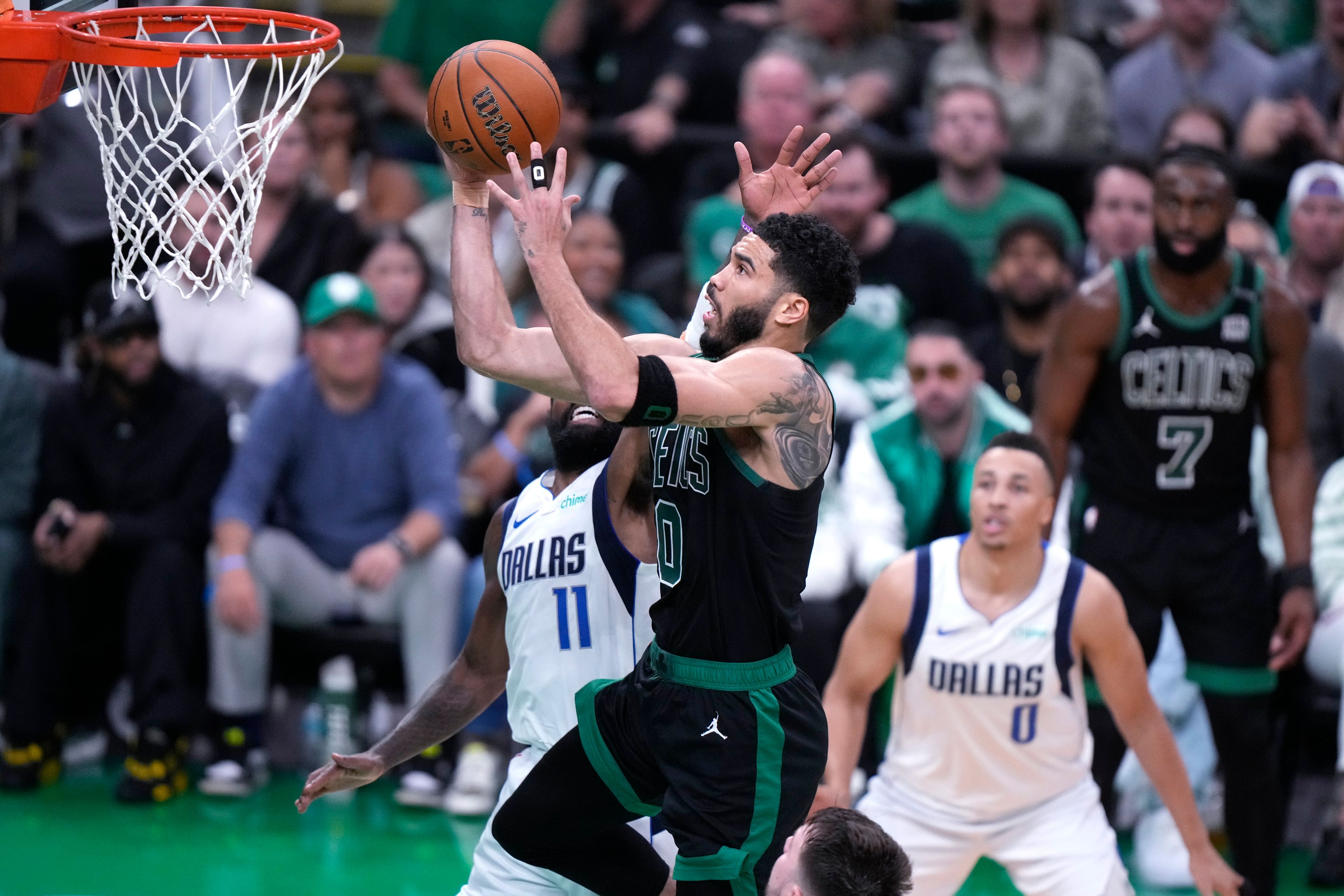 Boston Celtics forward Jayson Tatum (0) drives to the basket against Dallas Mavericks guard Kyrie Irving (11) during the second half of Game 2 of the NBA Finals basketball series, Sunday, June 9, 2024, in Boston.