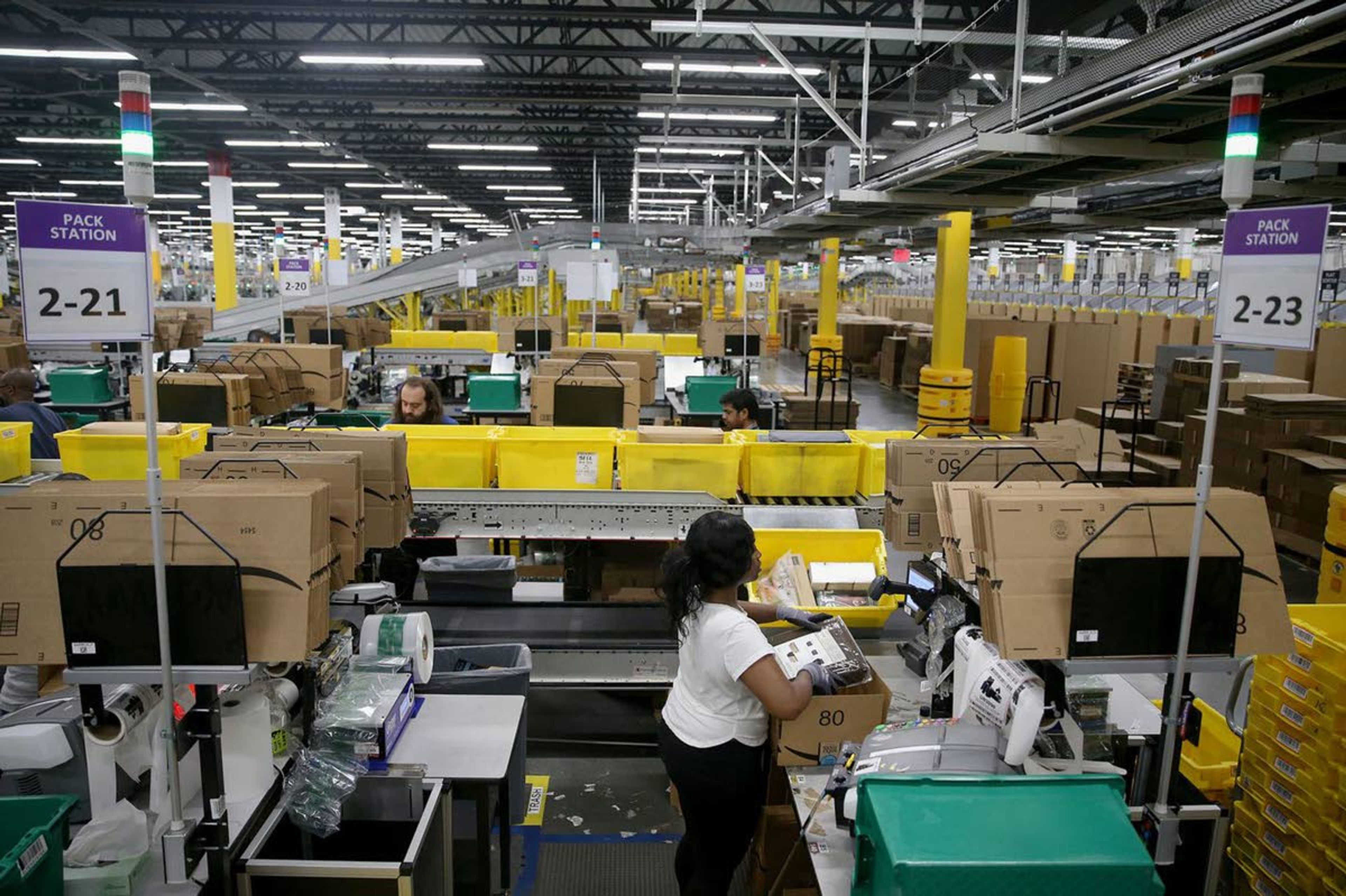 Workers box up orders to be shipped at the Amazon Fulfillment Center on June 14 in West Deptford, N.J. The robotic fulfillment center opened in September and is Amazon’s fourth such site in New Jersey.