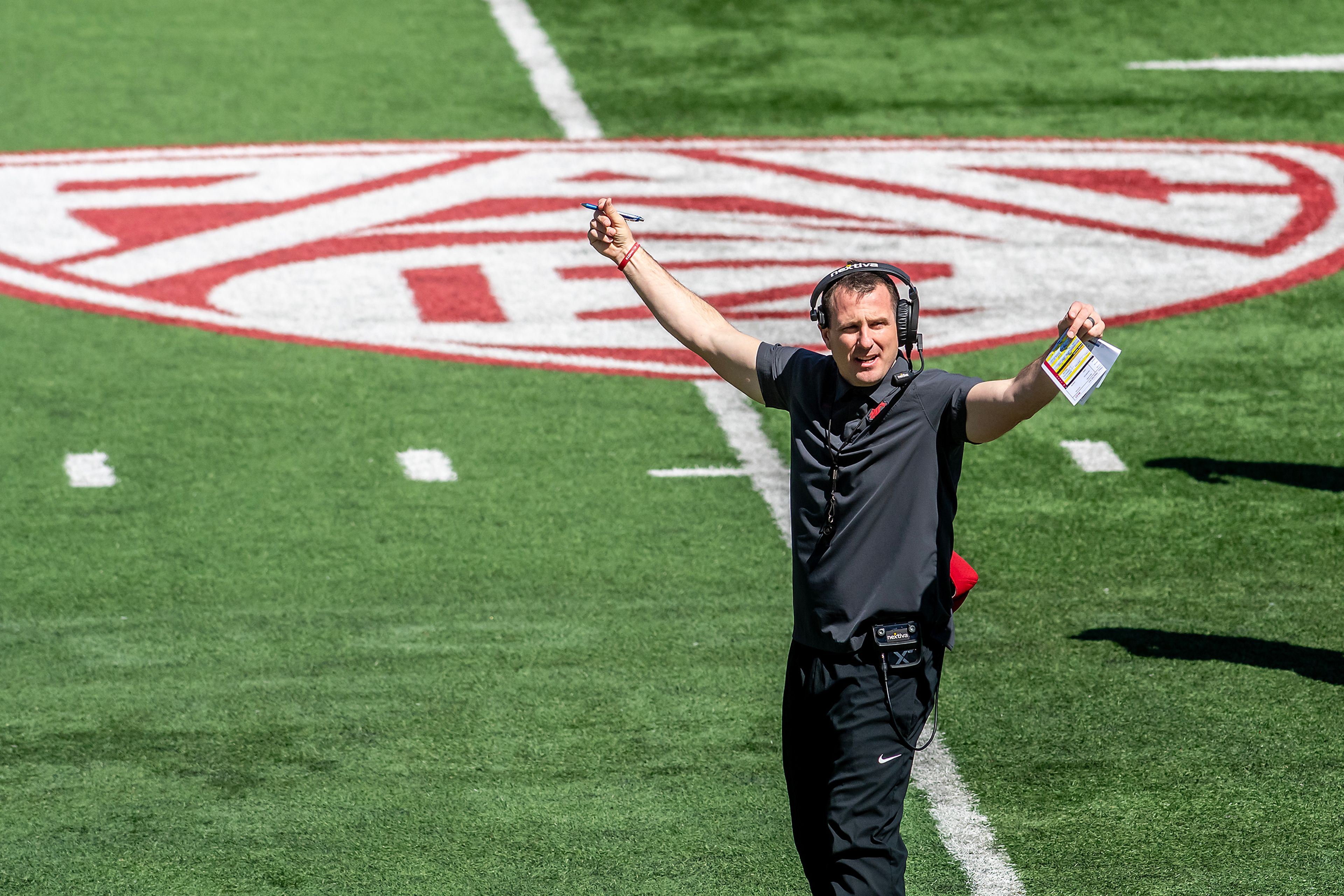 Washington State coach Jake Dickert motions to his team with the Pac-12 logo in the background during the second scrimmage of spring practice April 20 in Pullman.