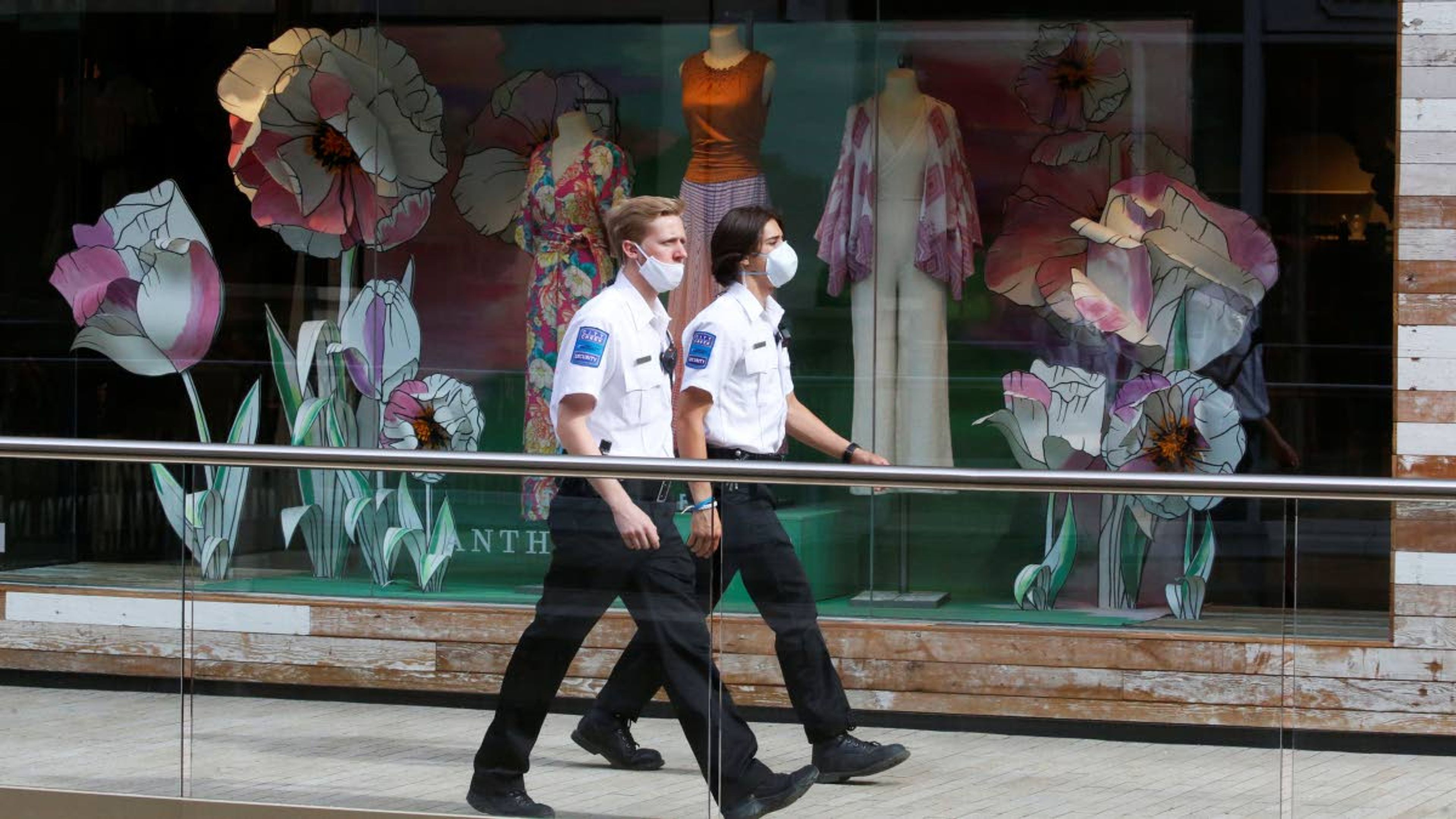 Masked security guards walk through City Creek Center Wednesday, May 6, 2020, in Salt Lake City. City Creek Center reopened today. Several major Utah malls have reopened after Utah leaders moved the state's COVID-19 risk level from high to moderate. (AP Photo/Rick Bowmer)