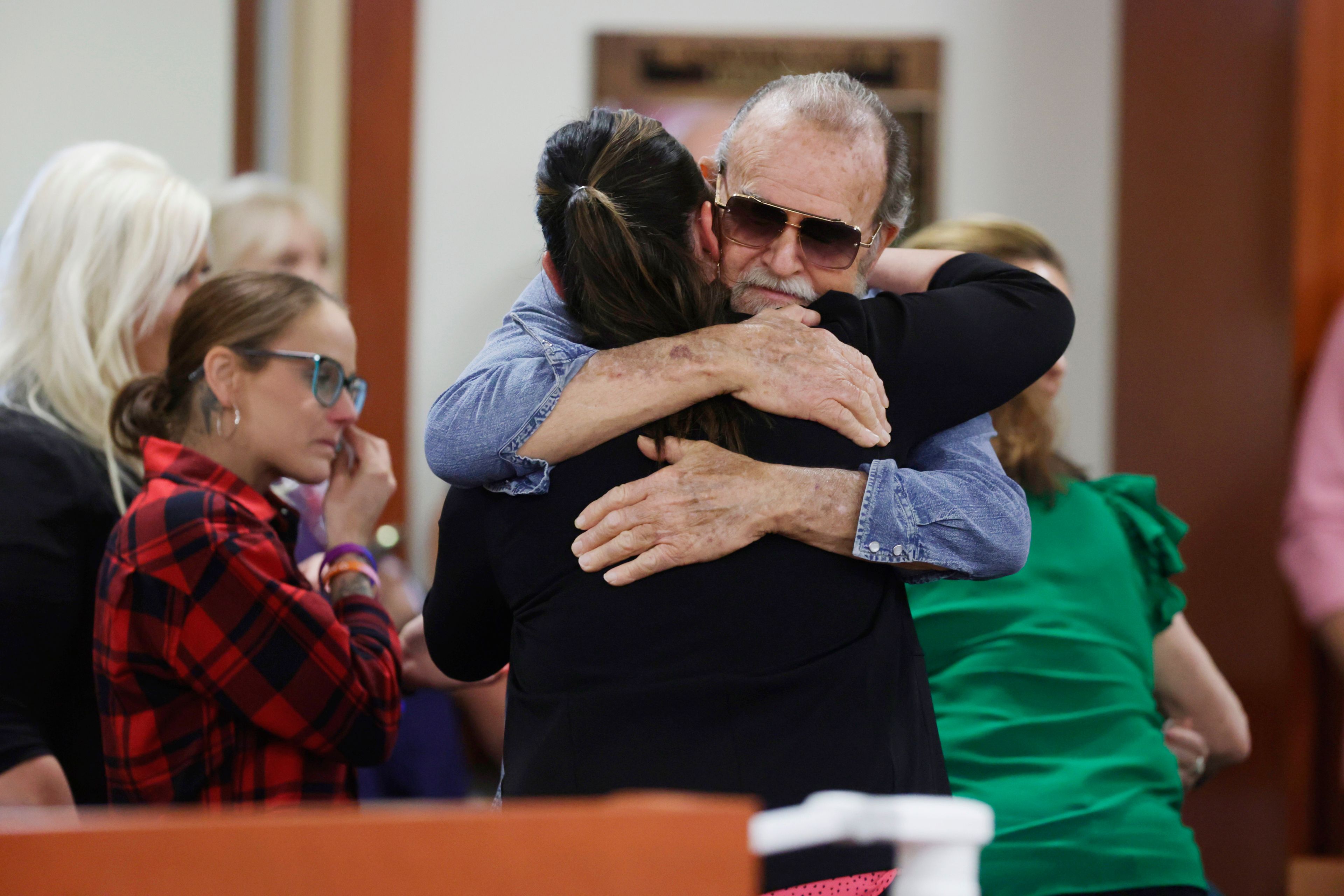 Larry Woodcock, gets a hug after the verdict in the Chad Daybell murder trial was read at the Ada County Courthouse in Boise, Idaho, on Thursday, May 30, 2024. Daybell was convicted of killing his wife and his new girlfriend's two youngest kids in a strange triple murder case that included claims of apocalyptic prophesies, zombie children and illicit affairs. (AP Photo/Kyle Green, Pool)