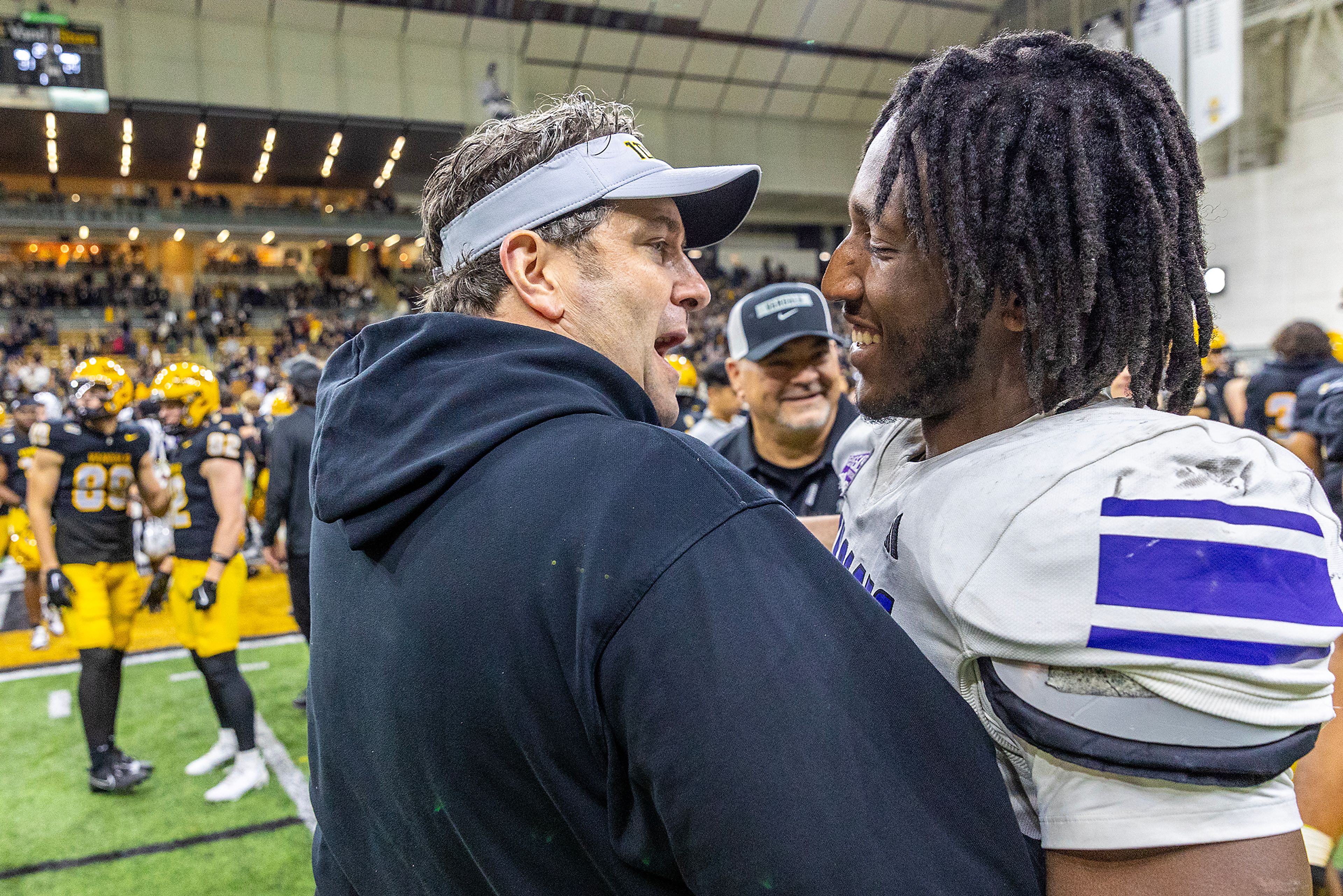 Idaho head coach Jason Eck embraces Weber State running back Chauncey Sylvester after a Big Sky conference game Saturday at the P1FCU Kibbie Dome in Moscow.