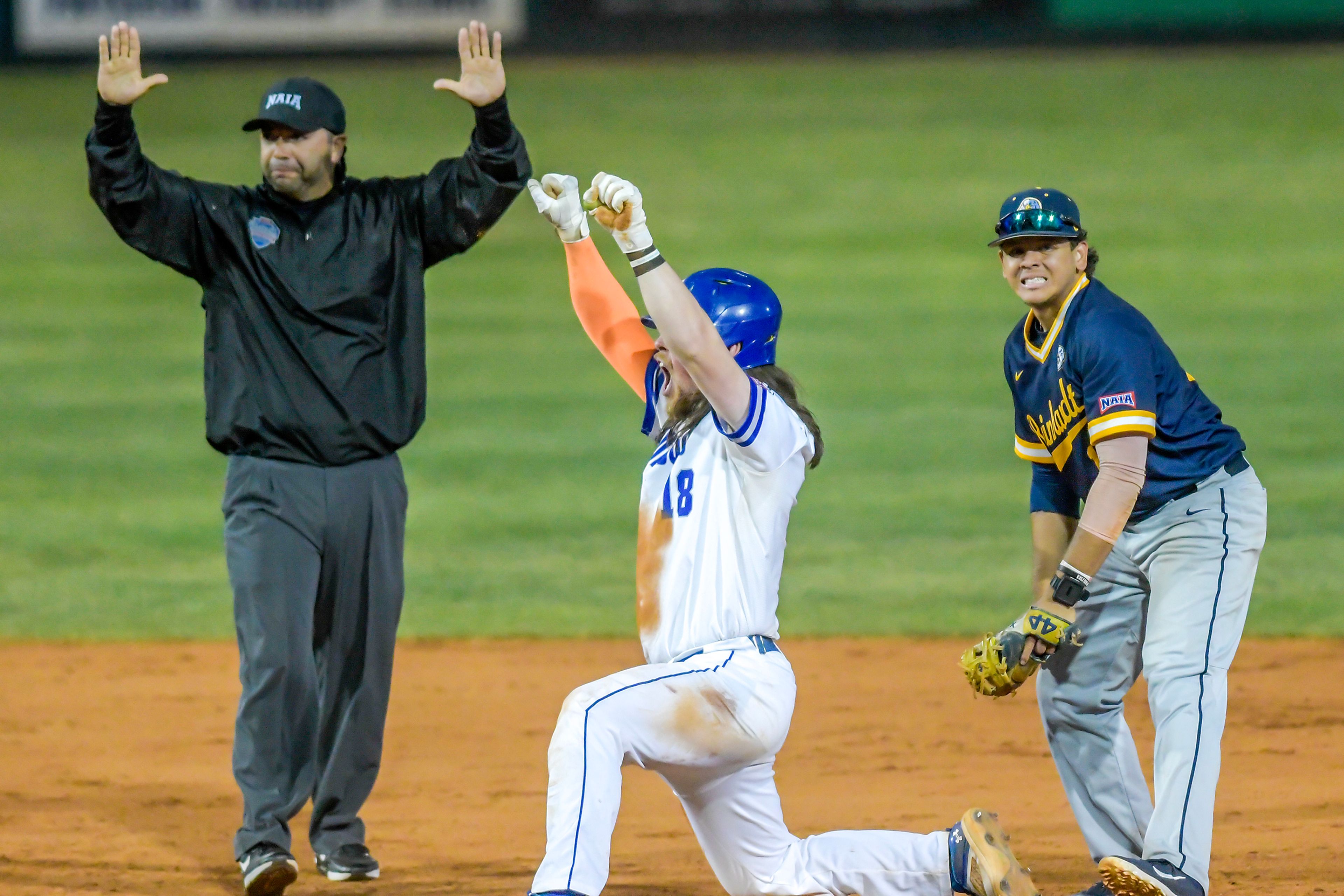 Tennessee Wesleyan’s Evan Magill celebrates getting to second base as Reinhardt’s Luis Mendoza reacts in Game 18 of the NAIA World Series at Harris Field Thursday in Lewiston.