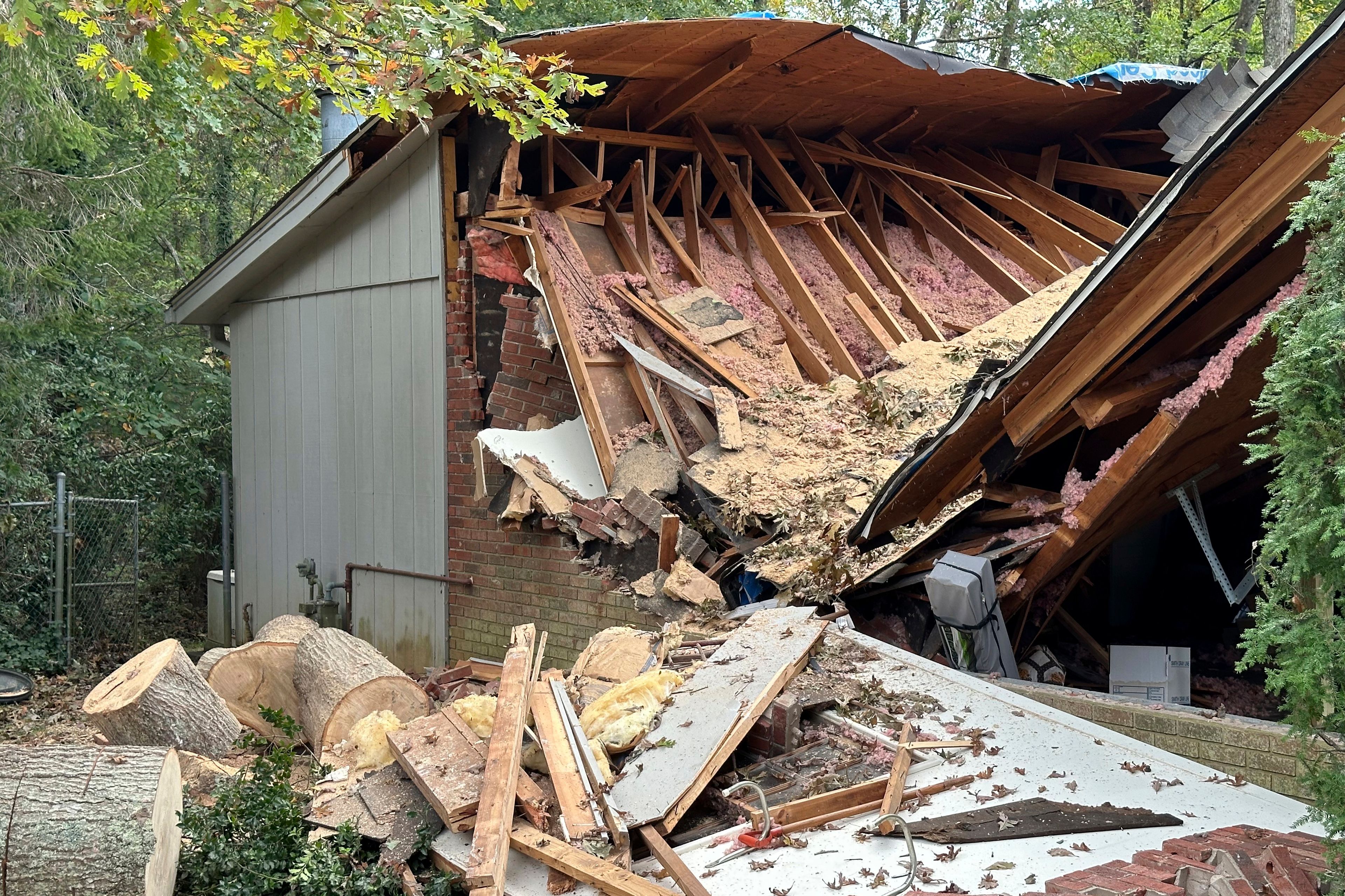 A damaged garage, caved in after a tree fell on it during the remnants of Hurricane Helene, is shown Friday, Oct. 4, 2024, in the Oak Forest neighborhood of Asheville, N.C. (AP Photo/Jeff Amy)