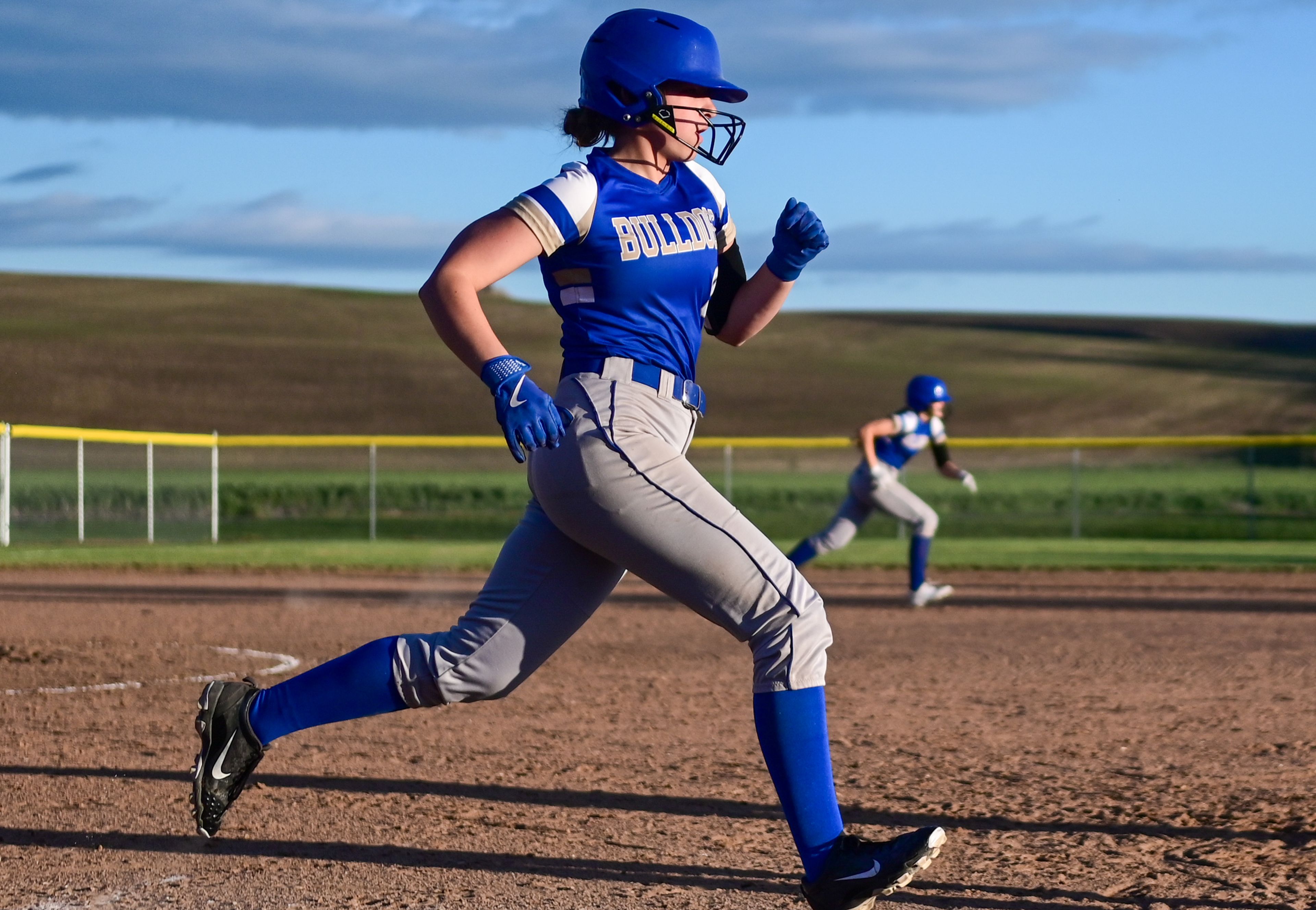 Genesee’s Mia Scharnhorst and a teammate both run in the direction of their respective bases during an Idaho 2A district tournament championship game Wednesday in Genesee.