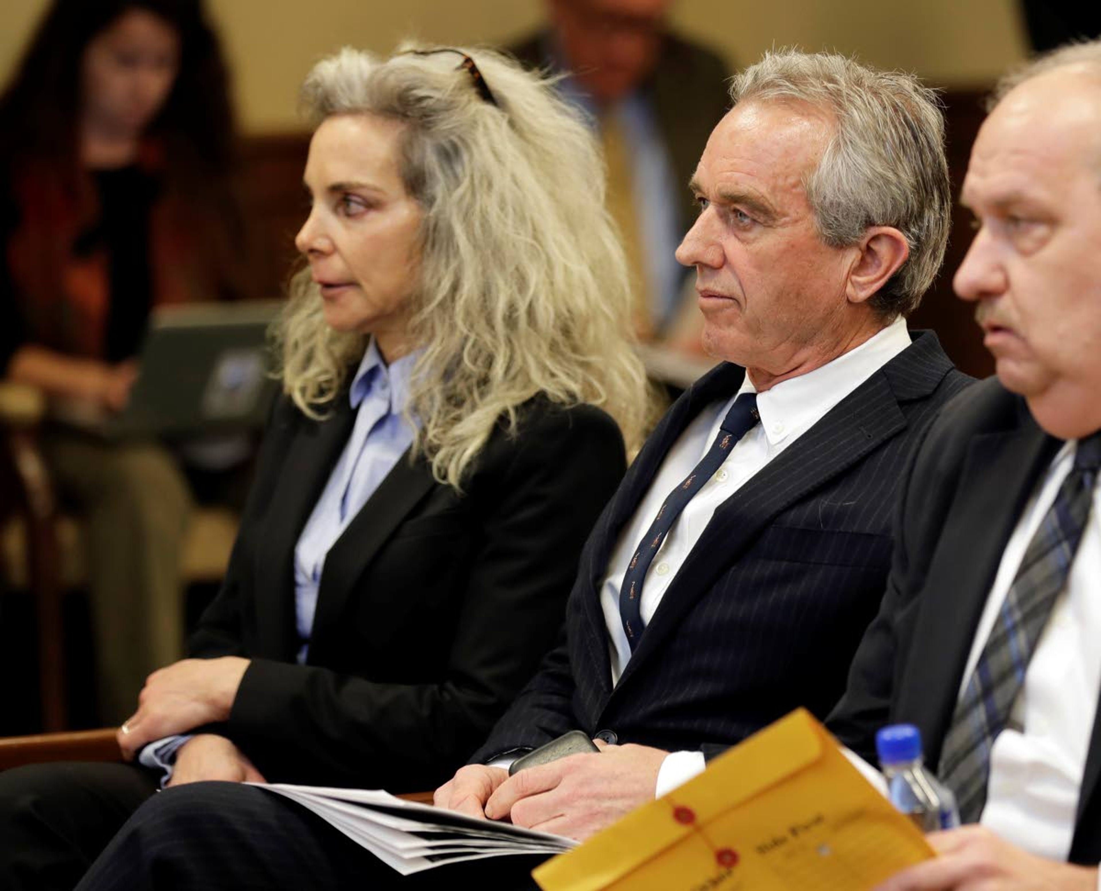 Robert Kennedy Jr., center, and Dr. Toni Bark, left, wait to testify Friday, Feb. 8, 2019, during a public hearing before the House Health Care & Wellness Committee at the Capitol in Olympia, Wash. Amid a measles outbreak that has sickened people in Washington state and Oregon, lawmakers heard public testimony on a bill that would remove parents' ability to claim a philosophical exemption to opt their school-age children out of the combined measles, mumps and rubella vaccine. Both Bark and Kennedy spoke against the bill. (AP Photo/Ted S. Warren)