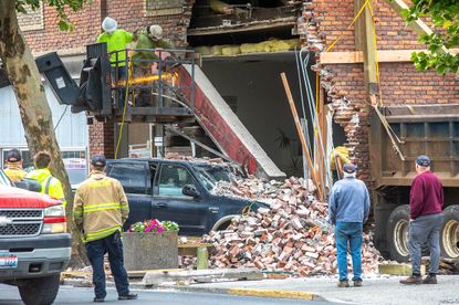 Workers removing a car from a building
