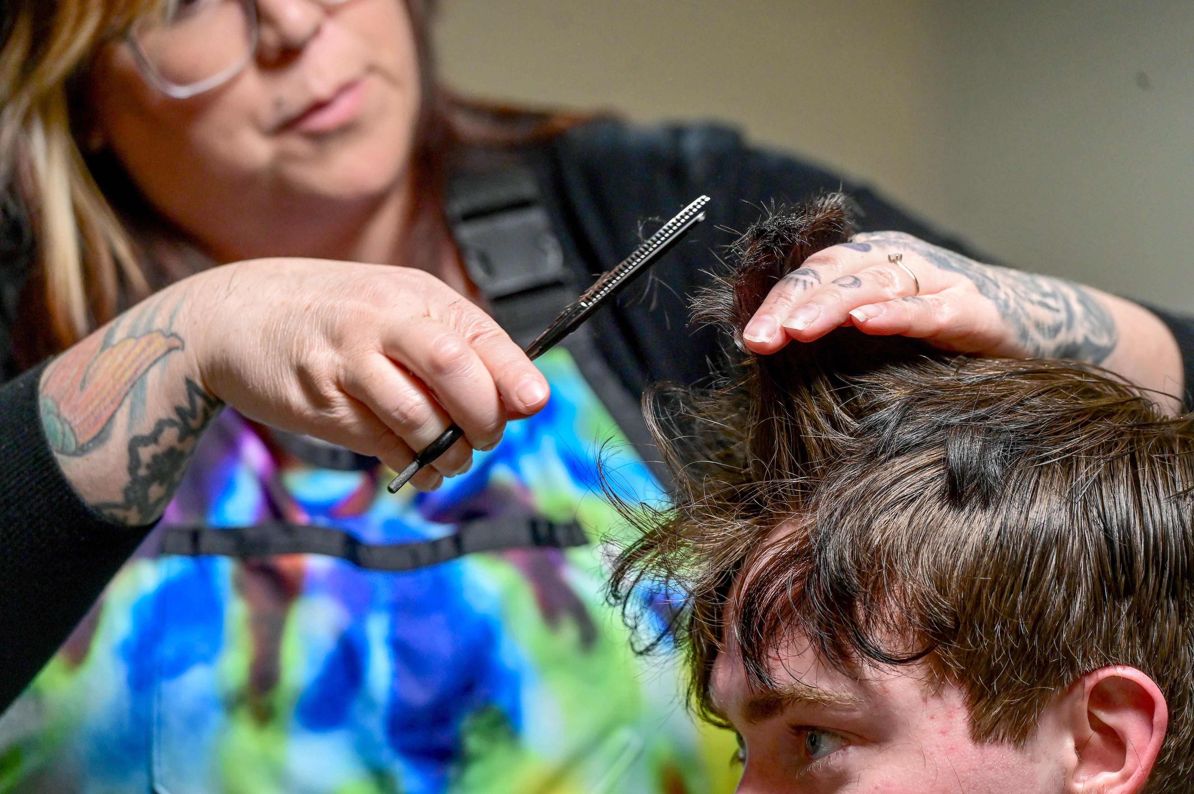 Eli Kastner, a Washington State University student, receives a haircut from barber Brooke Moore at the new expansion of Blood Diamond Ink that houses Diamond’s Edge Barbershop Friday, Feb. 23, in Pullman.