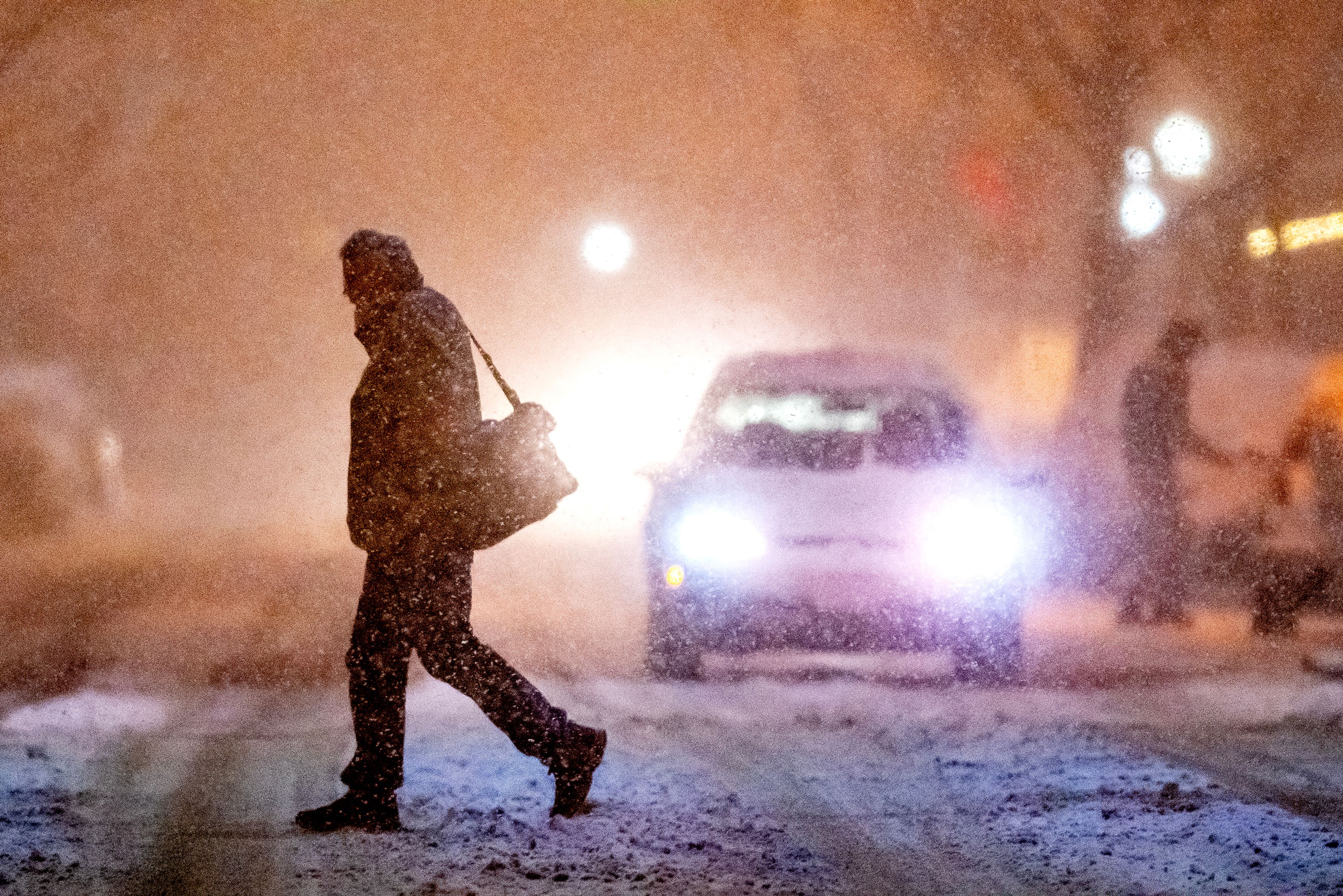 A person crosses Main Street as snow falls Thursday in Lewiston. Wet, fluffy flakes started falling on the Lewiston-Clarkston Valley around 5 p.m. Thursday and quickly blanketed the town. A Lewiston police dispatcher said that almost "any (road) with a hill" was closed Thursday evening. Police were scrambling to respond to several vehicle slideoffs, including a multiple-car incident on Bryden Canyon Road.