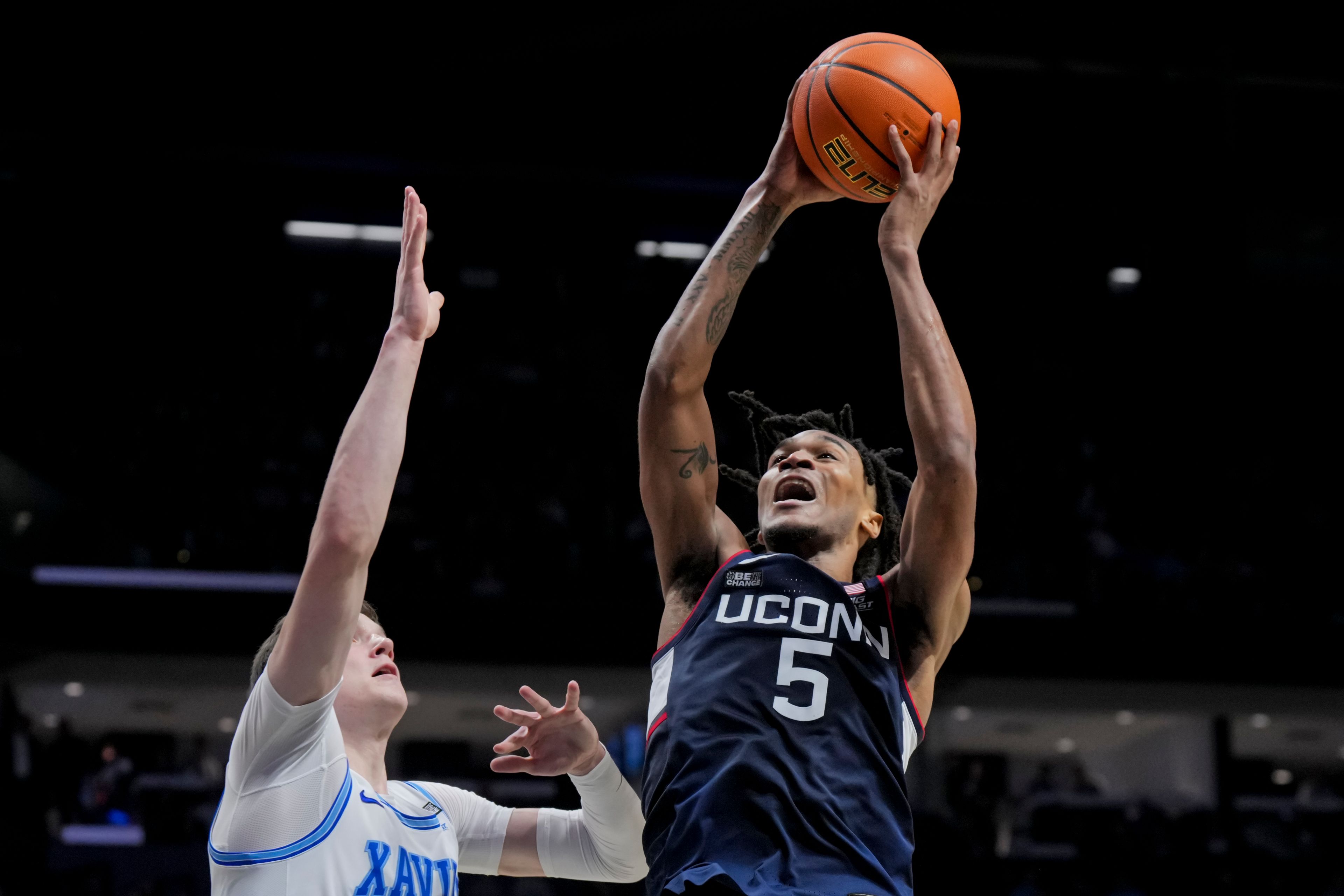 UConn guard Stephon Castle (5) drives to the basket against Xavier's forward Lazar Djokovic during the second half of an NCAA college basketball game Wednesday, Jan. 10, 2024, in Cincinnati. (AP Photo/Aaron Doster)