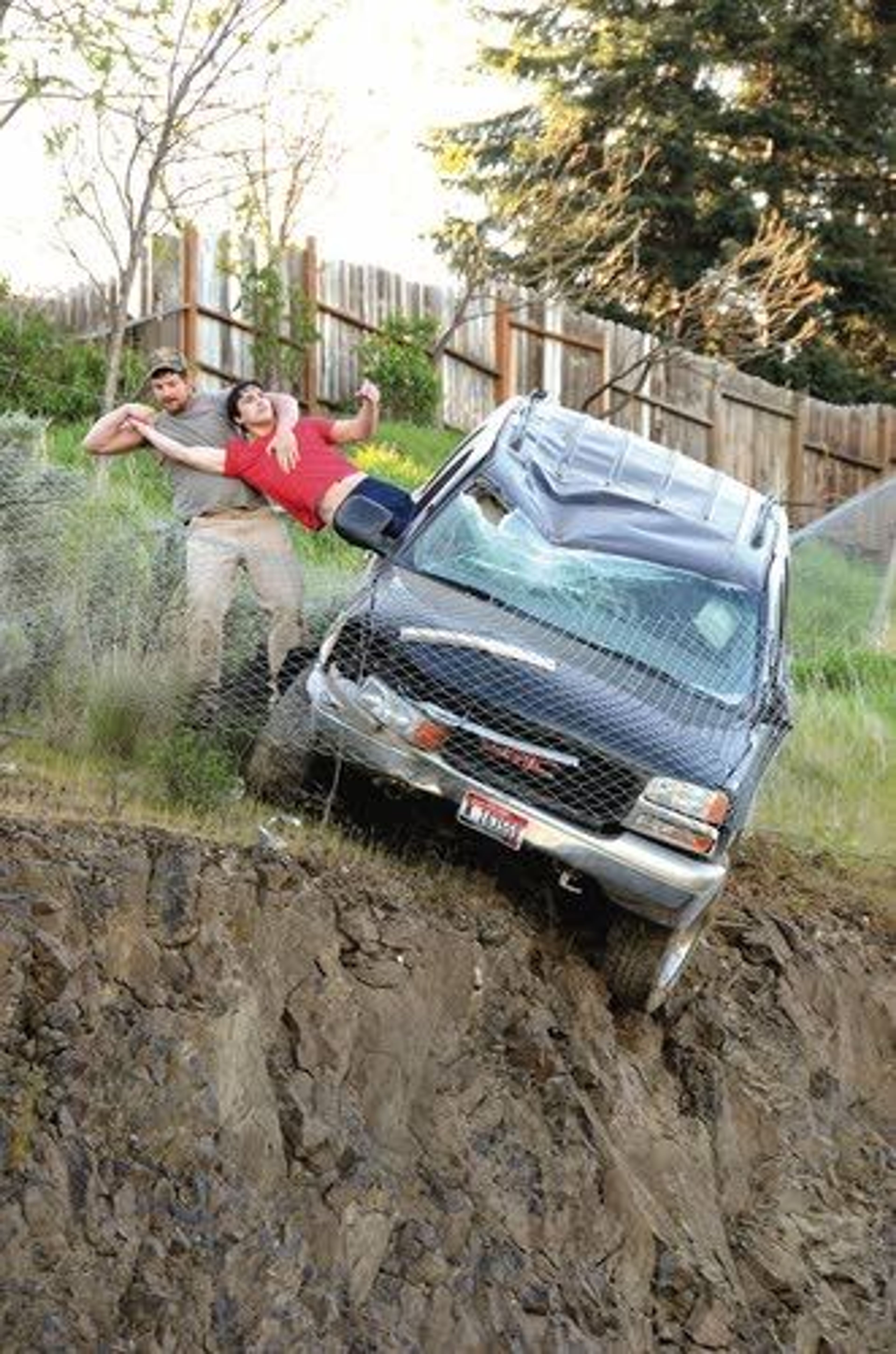 An unidentified passer-by pulls 23-year-old Mathew Sitko of Lewiston from an SUV Wednesday after smashing the window with a rock. The vehicle left Mayfair Drive in Lewiston and traveled downhill before being stopped by a chain-link fence just short of a vertical drop onto Bryden Canyon Road.