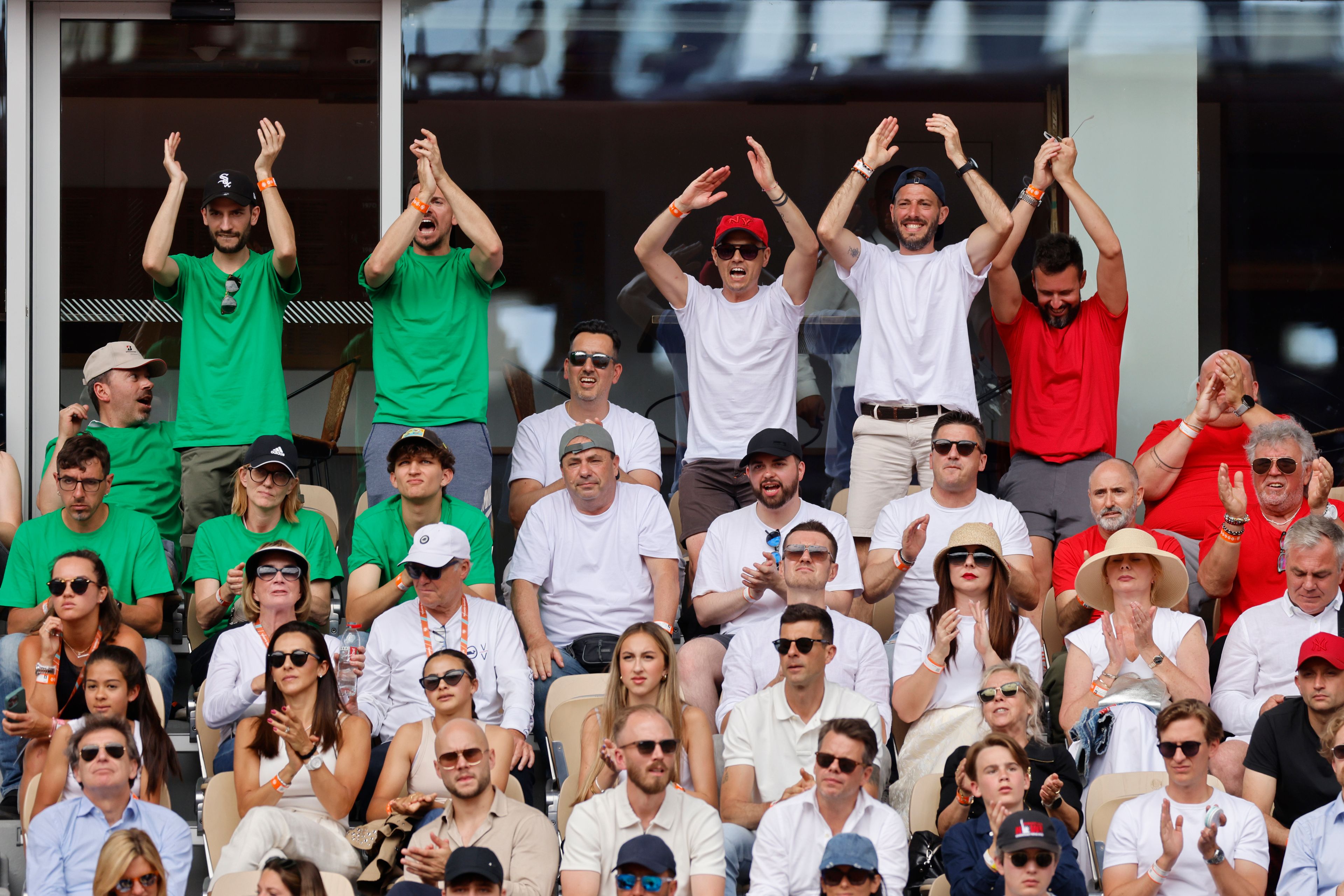 Tennis fans wearing t-shirt in the colours of the Italian flag support Italy's Jasmine Paolini as she plays against Poland's Iga Swiatek during the women's final of the French Open tennis tournament at the Roland Garros stadium in Paris, France, Saturday, June 8, 2024.