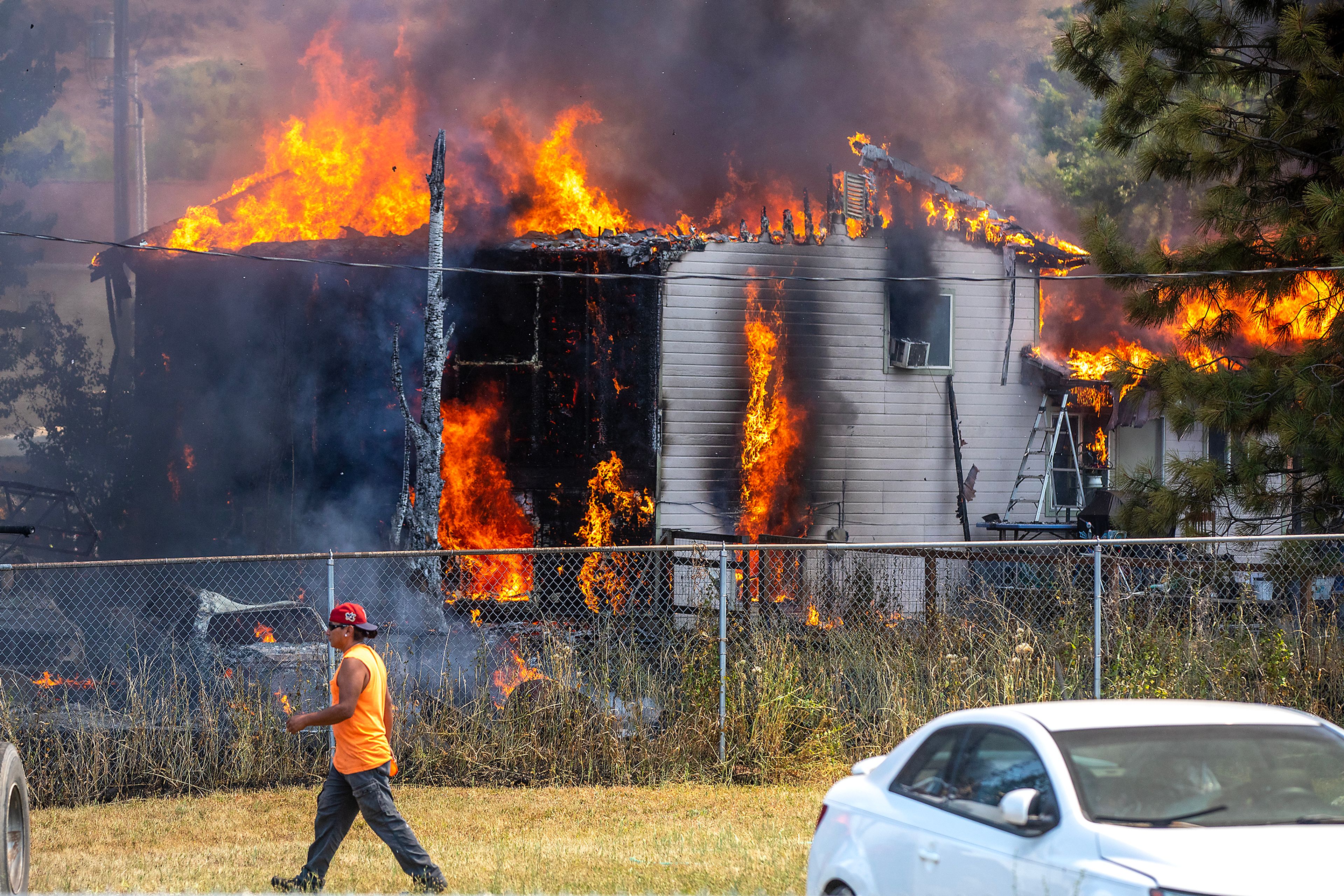 A home burns as firefighters work to set up hoses at the scene of a structure fire Friday on Lolo Street in Lapwai.