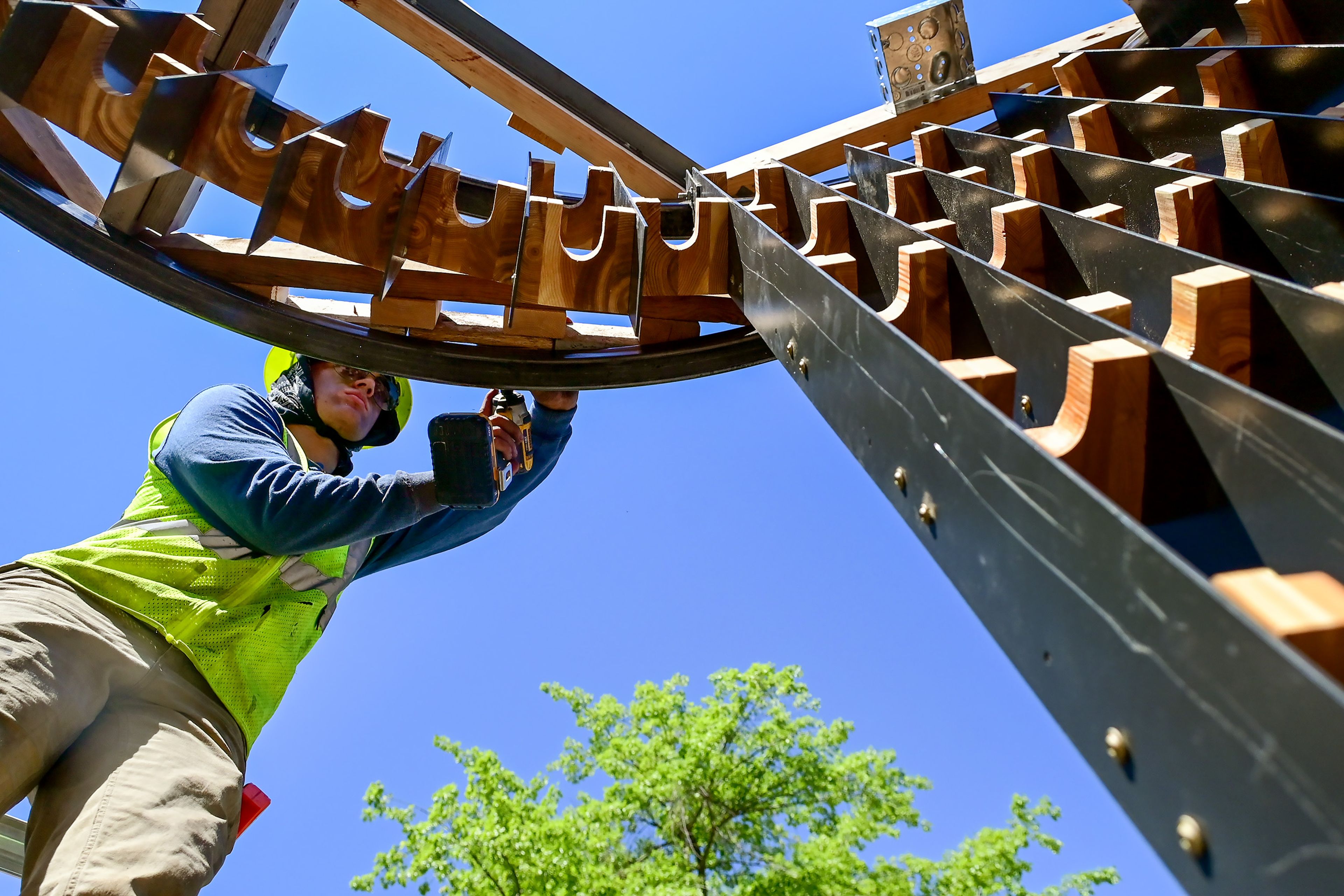 Bernardo Bautista, an incoming graduate architecture student at the University of Idaho, uses a drill to attach an overhang to one of the sitting areas of the Vandal Healing Garden and Memorial in Moscow on Tuesday. These spaces are built in a circular shape, with spots along the walls designed for leaving behind candles and messages.