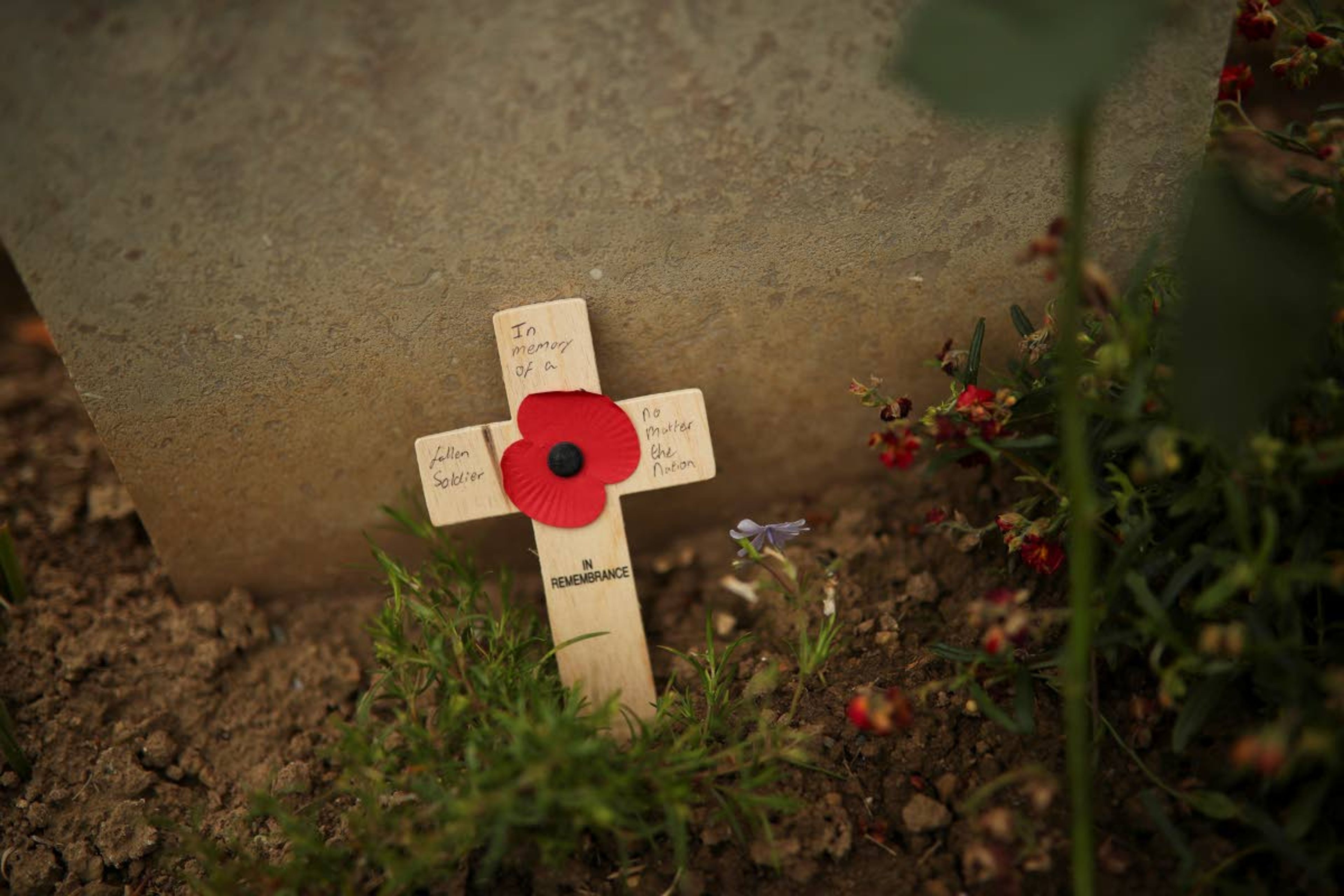 A small wooden cross that reads: "In memory of a fallen soldier no matter the nation" rests at the burial of a German soldier who died during the WWII at the Bayeux War cemetery in Bayeux, Normandy region of France, Wednesday, June 5, 2019. Extensive commemorations are being held in the U.K. and France to honor the nearly 160,000 troops from Britain, the United States, Canada and other nations who landed in Normandy on June 6, 1944 in history's biggest amphibious invasion. (AP Photo/Francisco Seco)