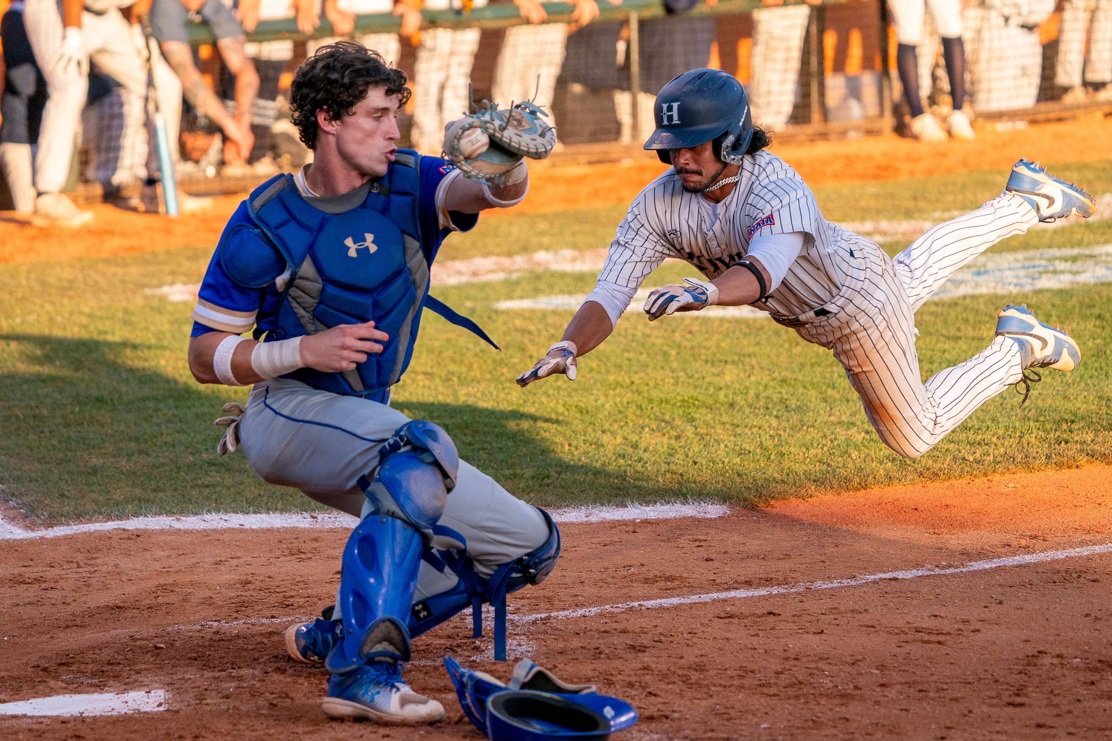 Hope International’s David Rivera, right, leaps into home plate to score during Game 19 of the NAIA World Series against Tennessee Wesleyan on Friday at Harris Field in Lewiston.