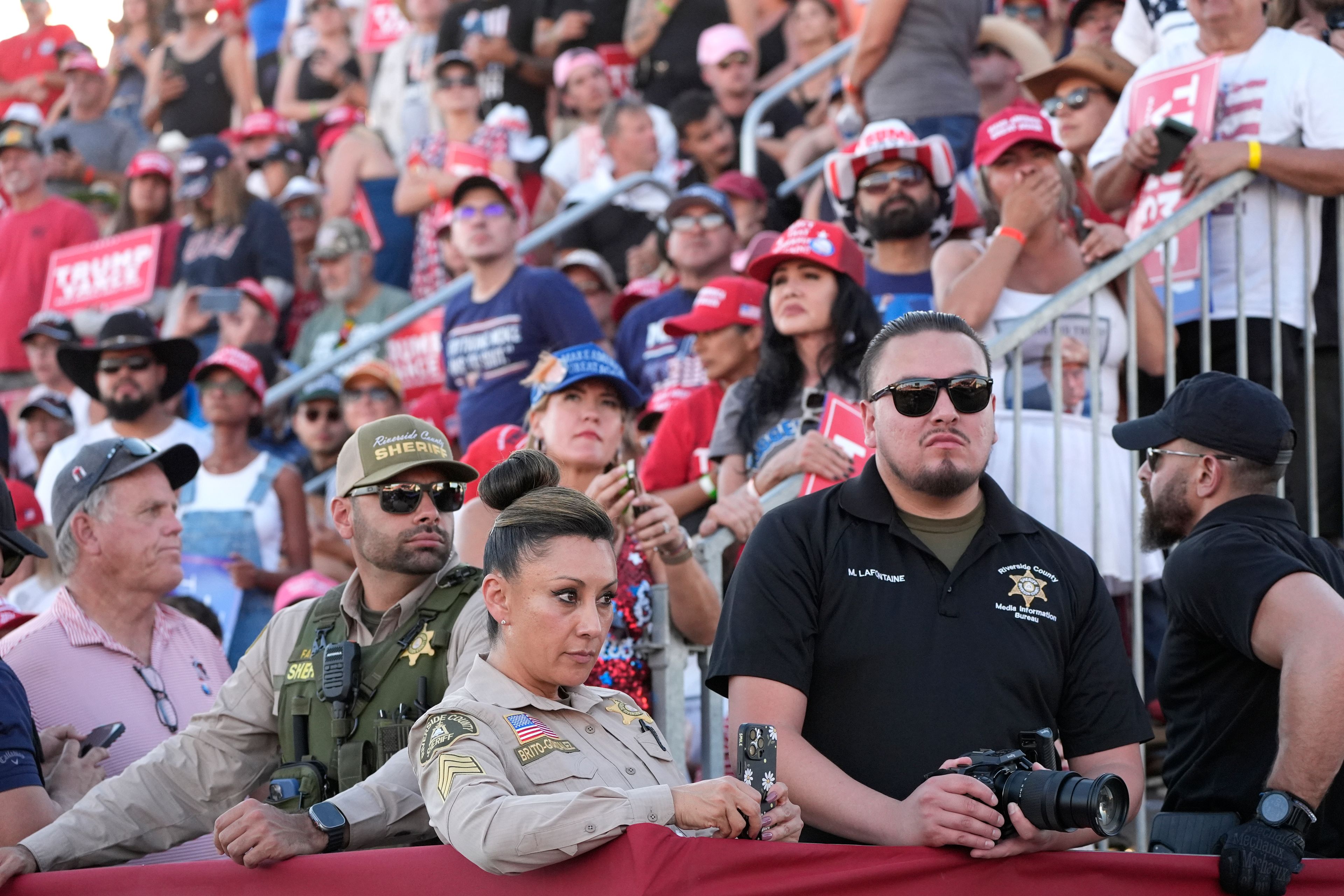 Attendees and members of law enforcement watch as Republican presidential nominee former President Donald Trump arrives to speak at a campaign rally at the Calhoun Ranch, Saturday, Oct. 12, 2024, in Coachella, Calif. (AP Photo/Alex Brandon)