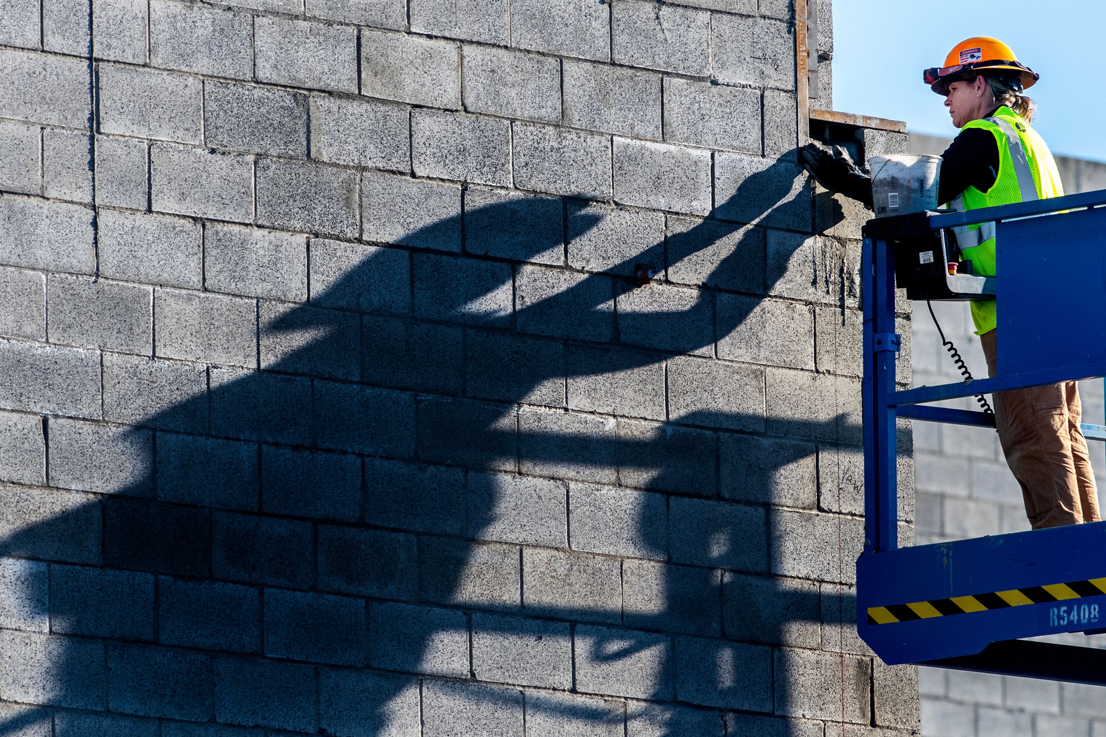 A workers labors away on the new Courthouse as a long shadow is cast Tuesday, Nov. 28, in Lewiston.