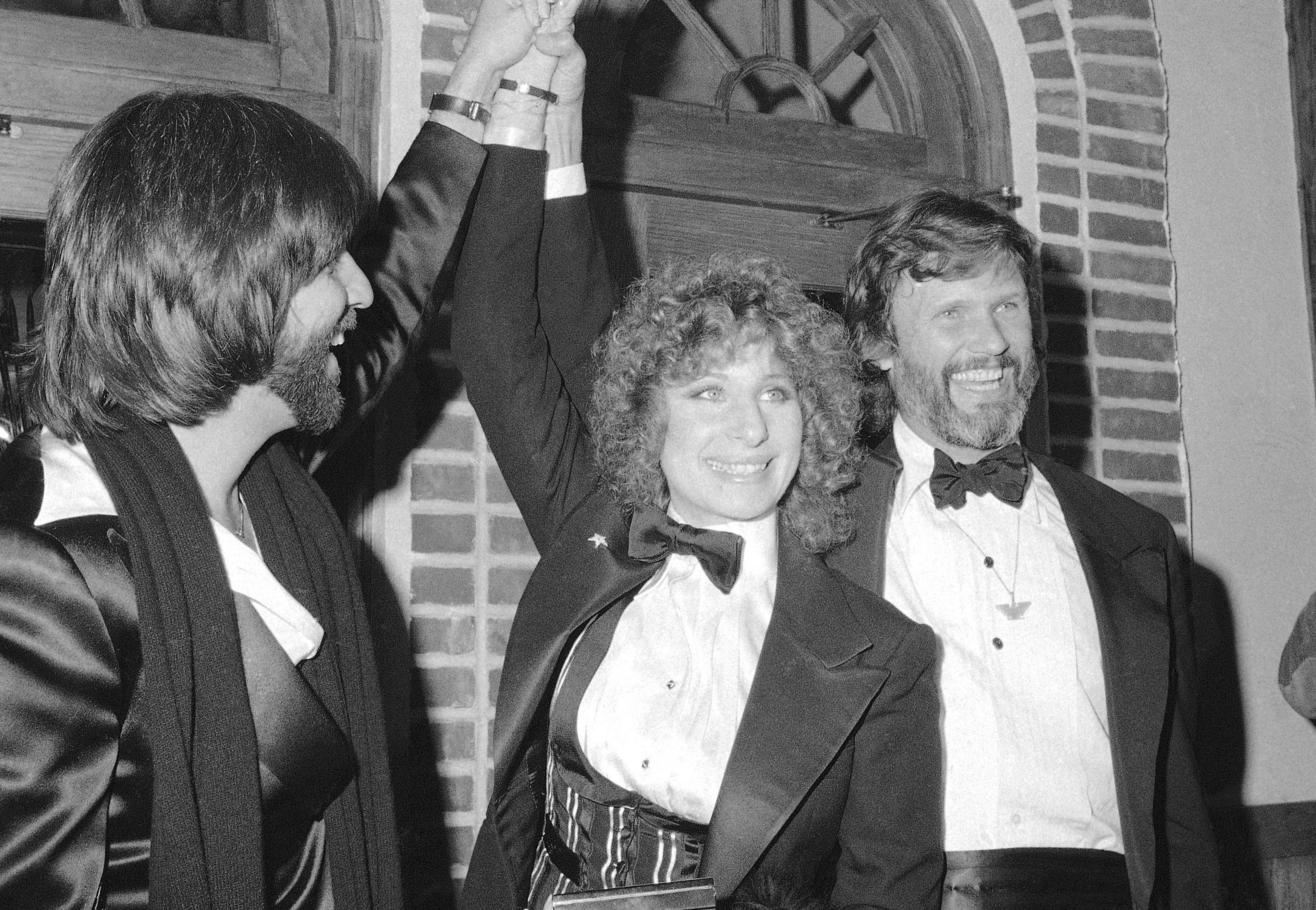 FILE - Producer Jon Peters, from left, Barbra Streisand and Kris Kristofferson appear at a preview of the film, "A Star is Born," in Dec. 23, 1976, in New York. Kristofferson, a Rhodes scholar with a deft writing style and rough charisma who became a country music superstar and A-list Hollywood actor, has died Saturday, Sept. 28, 2024. (AP Photo/Suzanne Vlamis, File)