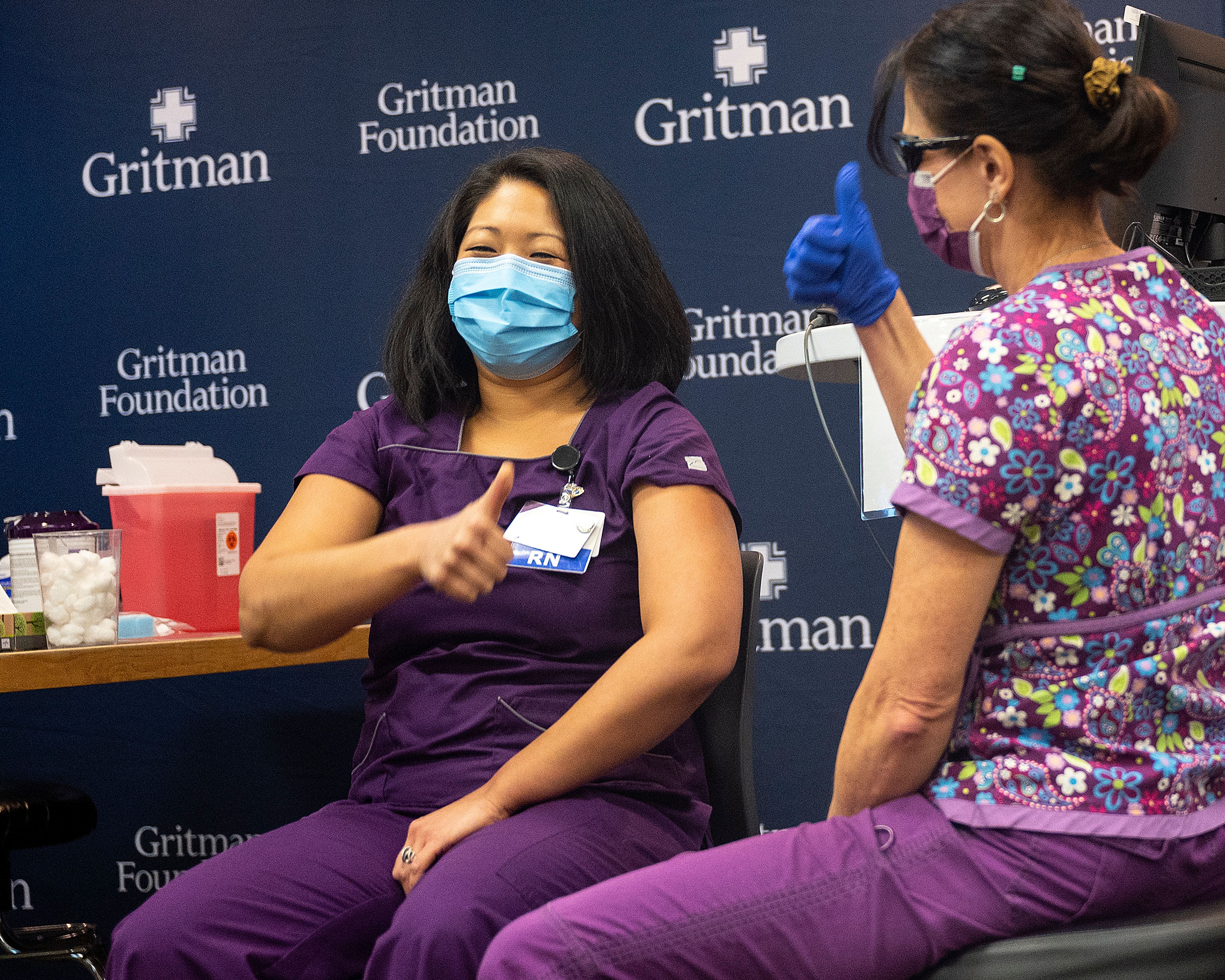 Gritman Medical Center nurse Nina Benichou gives a thumbs up after being the first person at the medical center to be inoculated with the COVID-19 vaccine on Friday in Moscow.