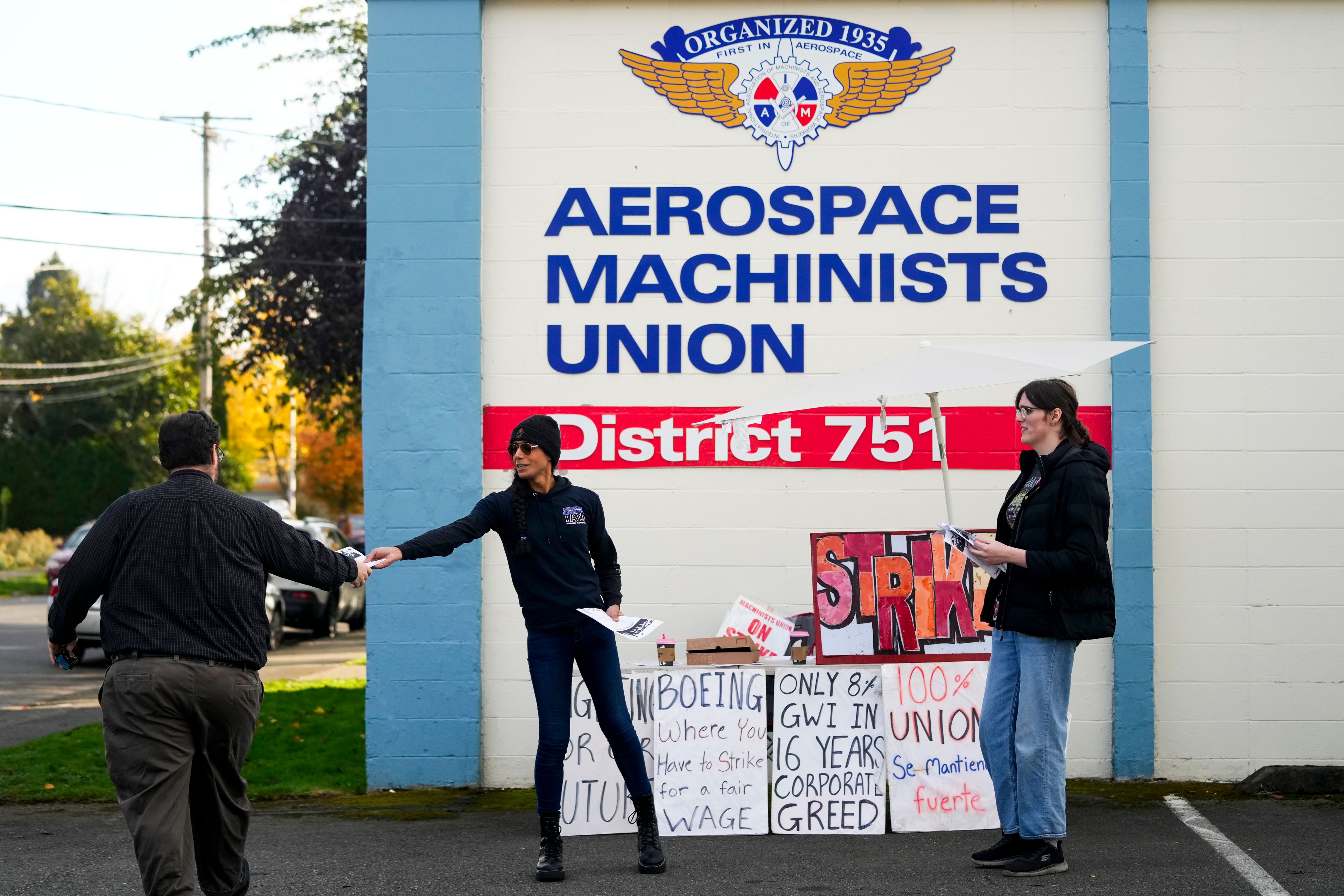 Boeing calibration specialist Eep BolaÃ±o, second from left, and machinist Ky Carlson, right, hand out flyers to other employees arriving to vote on a new contract offer from the company, Wednesday, Oct. 23, 2024, at the Aerospace Machinists Union hall in Renton, Wash. (AP Photo/Lindsey Wasson)