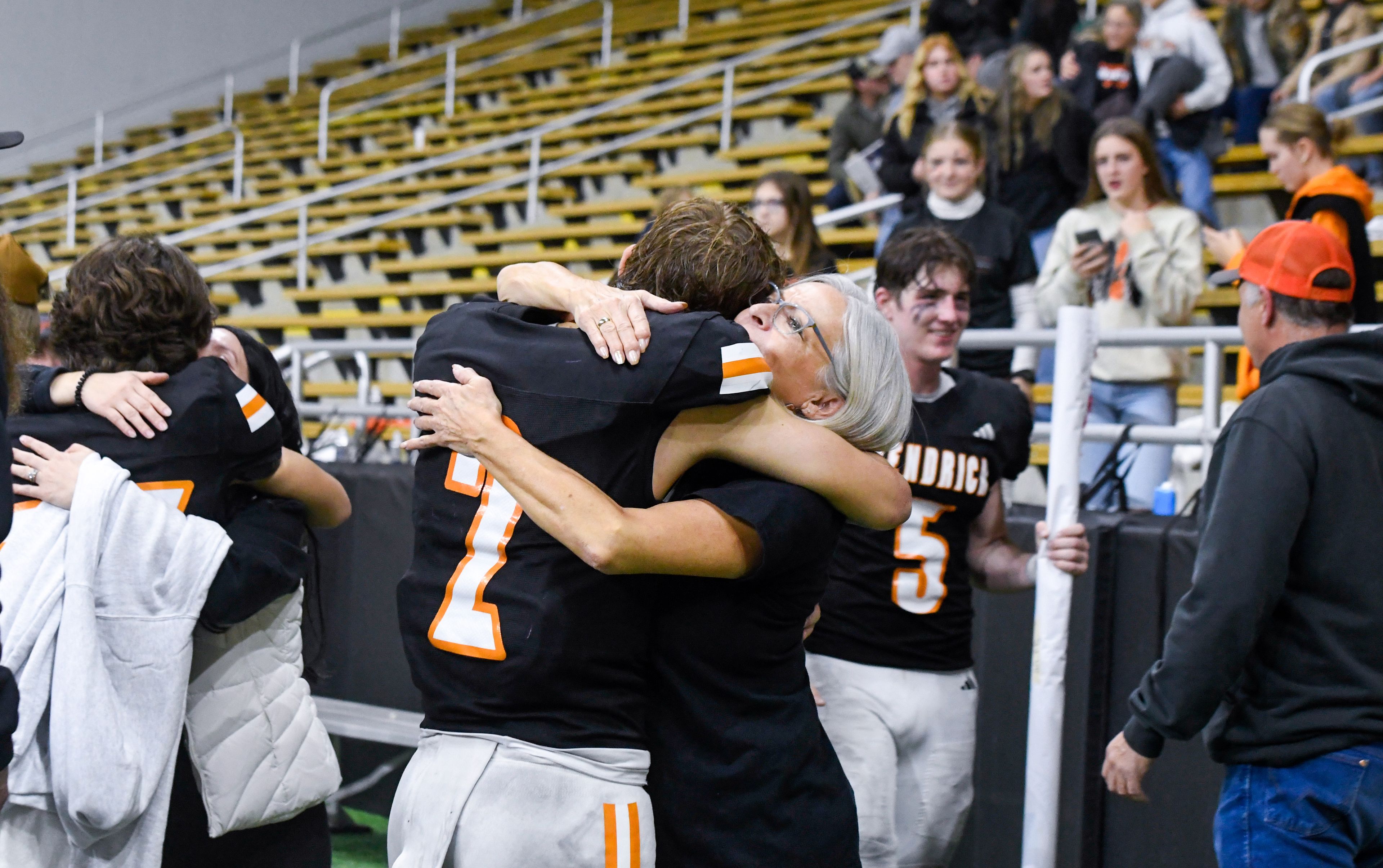 Kendrick players, including Ralli Roetcisoender, center, are greeted by loved ones after their Idaho Class 2A state championship win over Butte County at the P1FCU Kibbie Dome in Moscow.