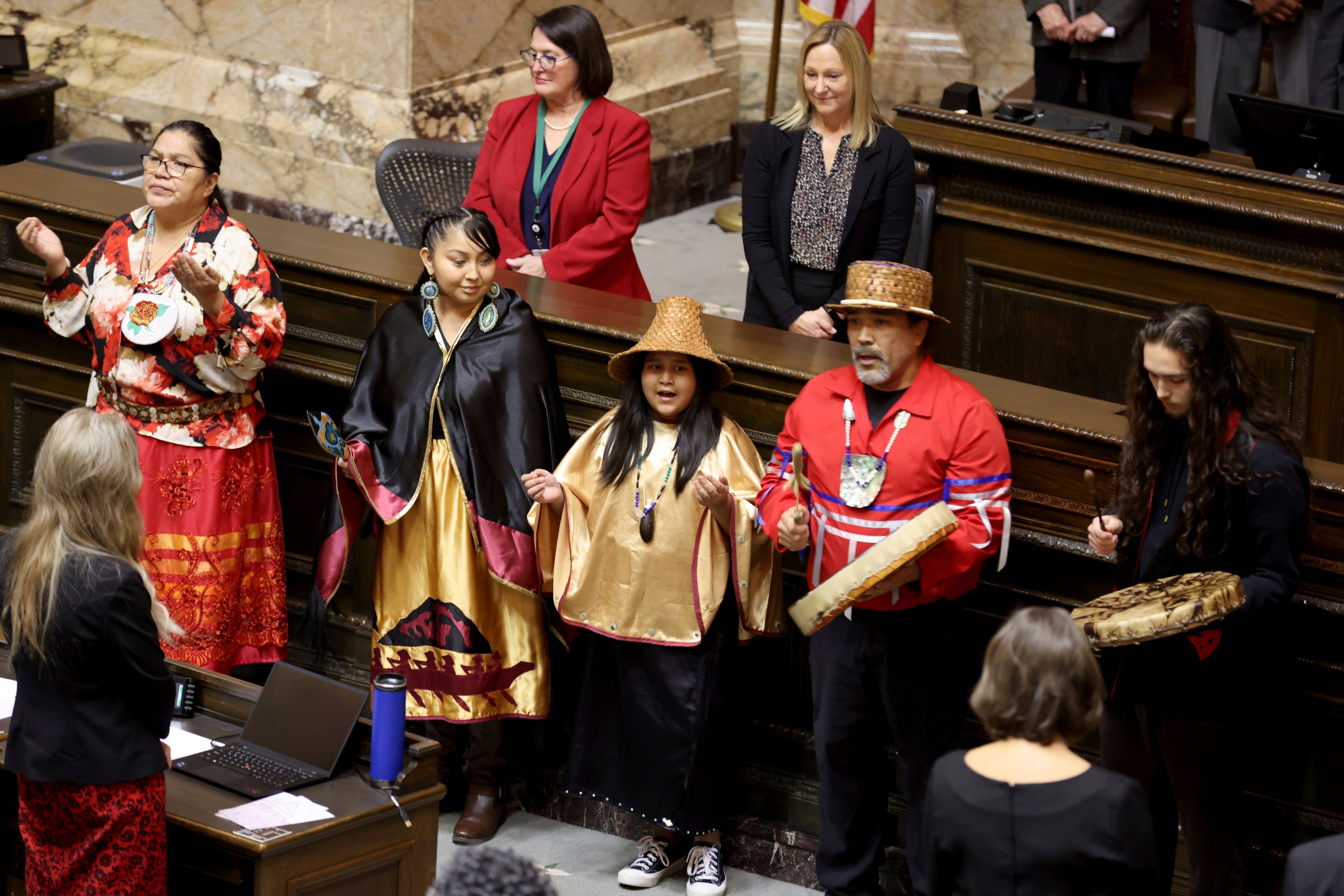 Members of the Nisqually Council and Canoe family perform a welcome song on the first day of the legislative session at the Washington state Capitol in Olympia, Wash., on Monday, Jan. 9, 2023. (Karen Ducey/The Seattle Times via AP)