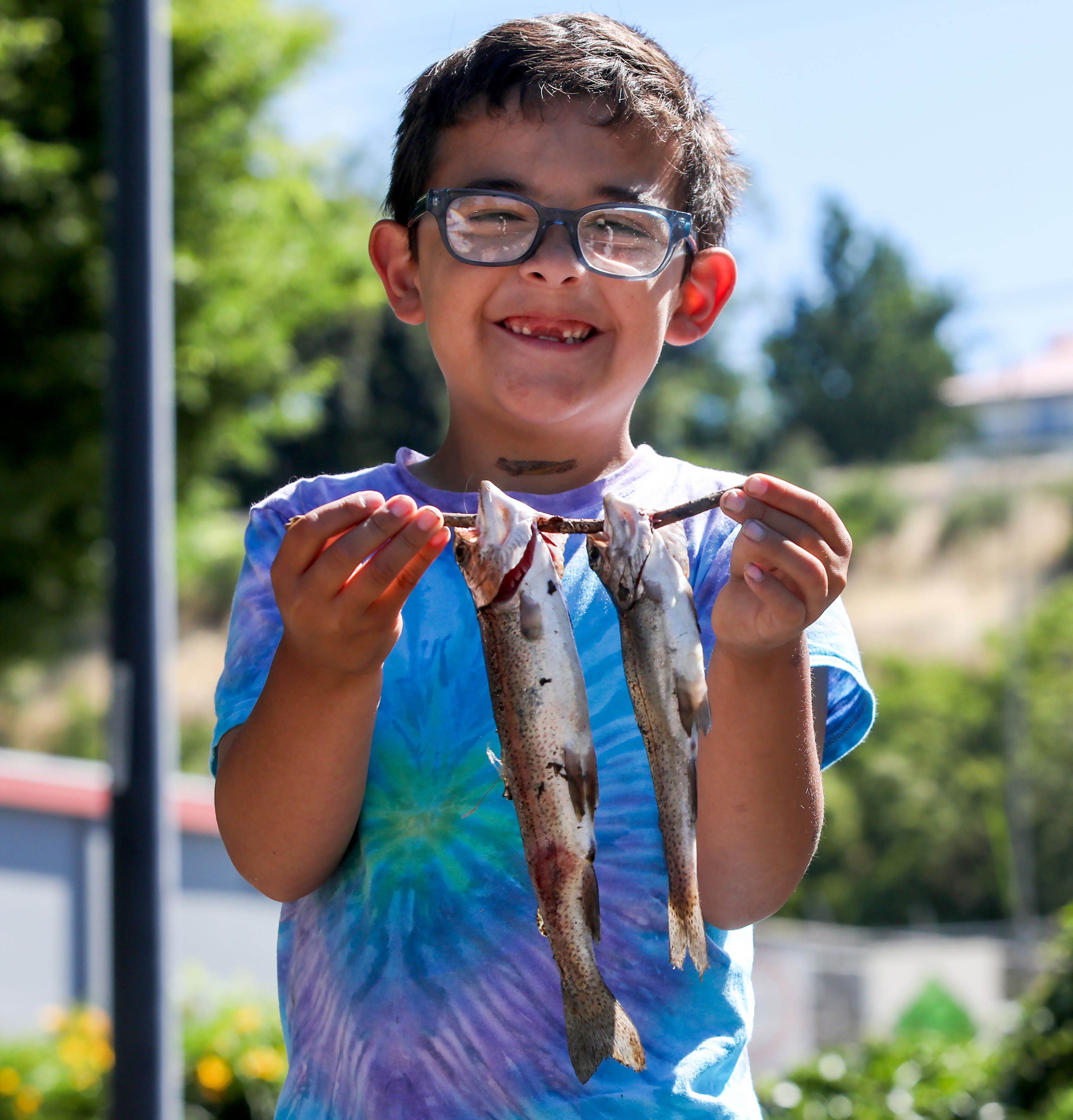 Louie Palmer, 8, holds up two Rainbow trout, his first ever catches, caught at Kiwanis Park Pond during Idaho's Free Fishing Day on Saturday in Lewiston.