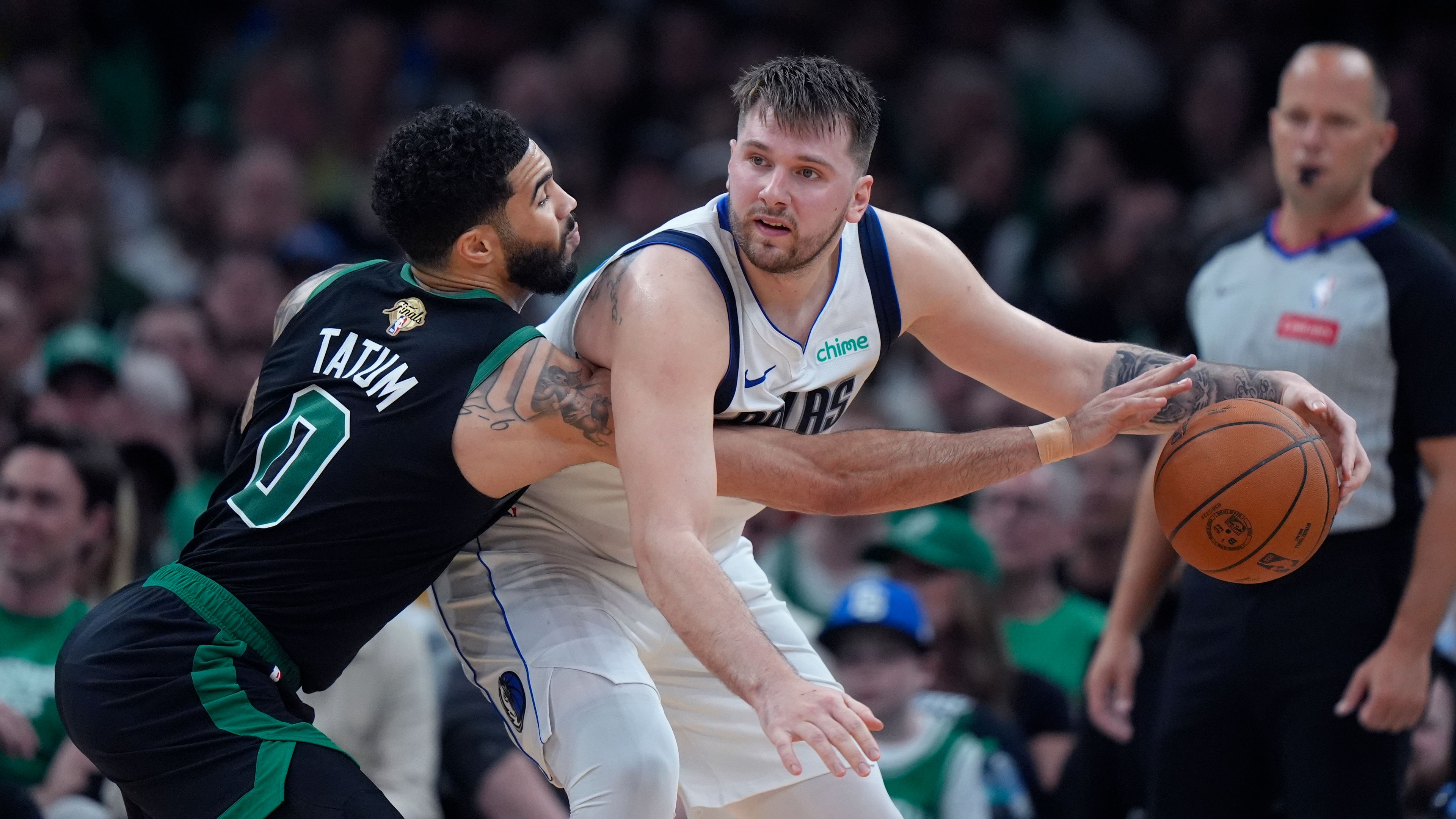 Boston Celtics forward Jayson Tatum (0) pressures Dallas Mavericks guard Luka Doncic, front right, during the first half of Game 2 of the NBA Finals basketball series, Sunday, June 9, 2024, in Boston.