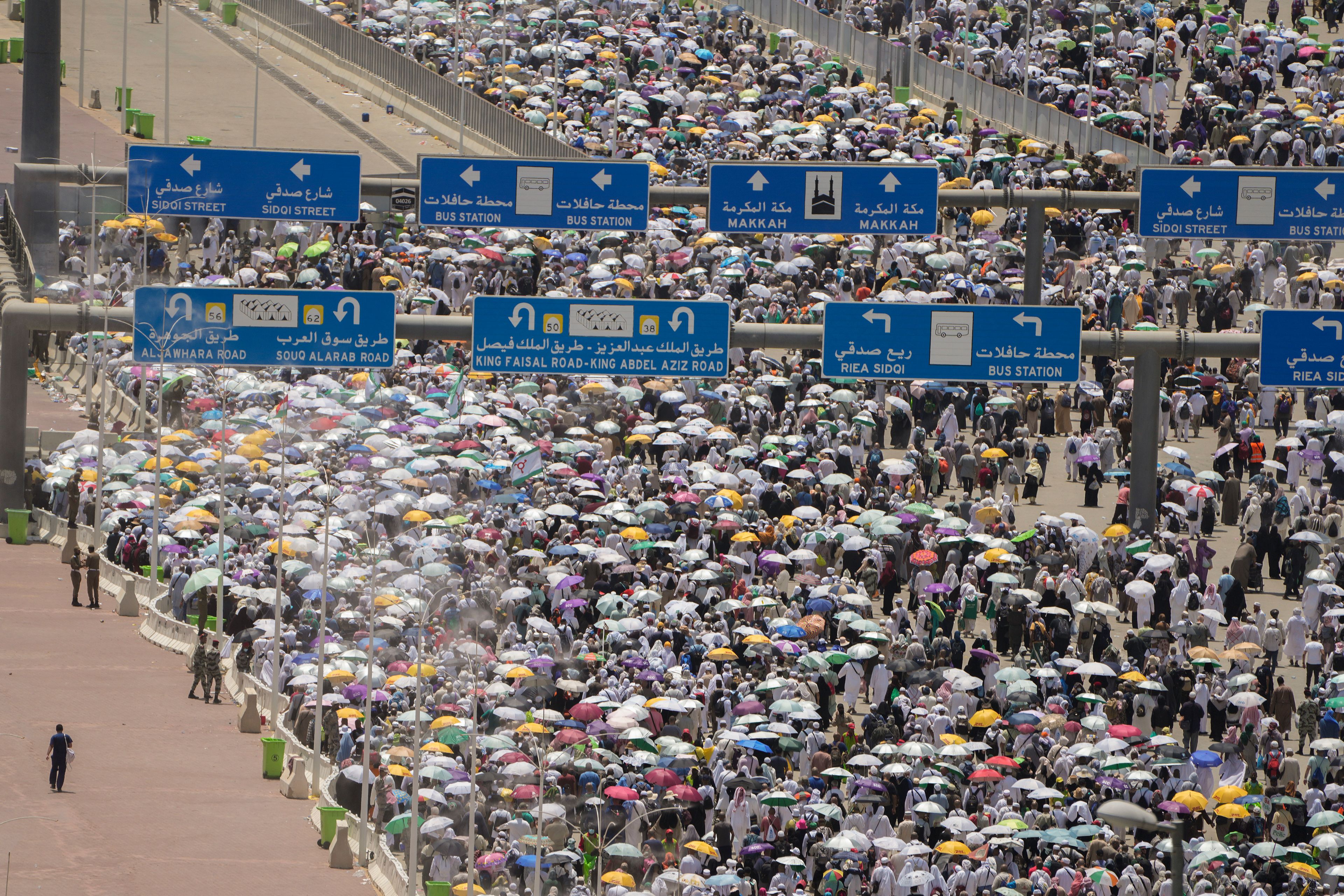 FILE - Muslim pilgrims hold umbrellas as they walk to cast stones at pillars in the symbolic stoning of the devil during the annual Hajj, in Mina near the holy city of Mecca, Saudi Arabia, on June 30, 2023. Once a year, Muslim pilgrims coming to Saudi Arabia from around the world unite in a series of religious rituals and acts of worship as they perform Hajj, one of the pillars of Islam.