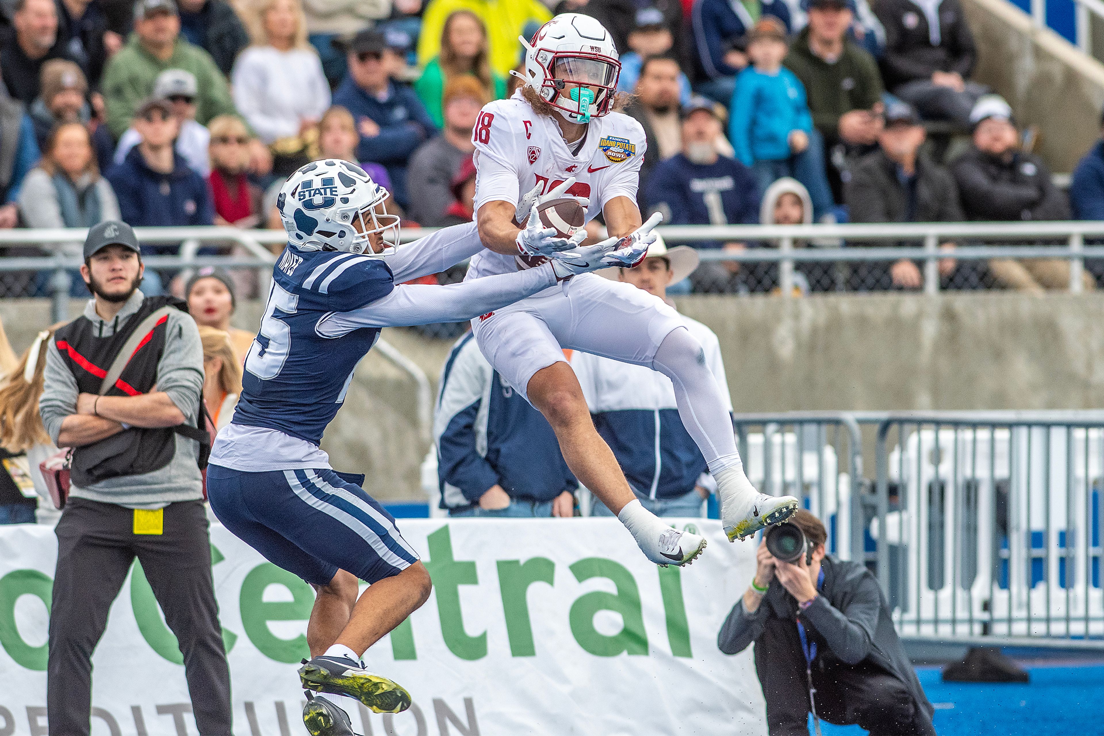 Washington State wide receiver Joshua Meredith makes a catch as Utah State cornerback D' Angelo Mayes tries to break it up during the Famous Idaho Potato Bowl Monday at Albertsons Stadium in Boise.