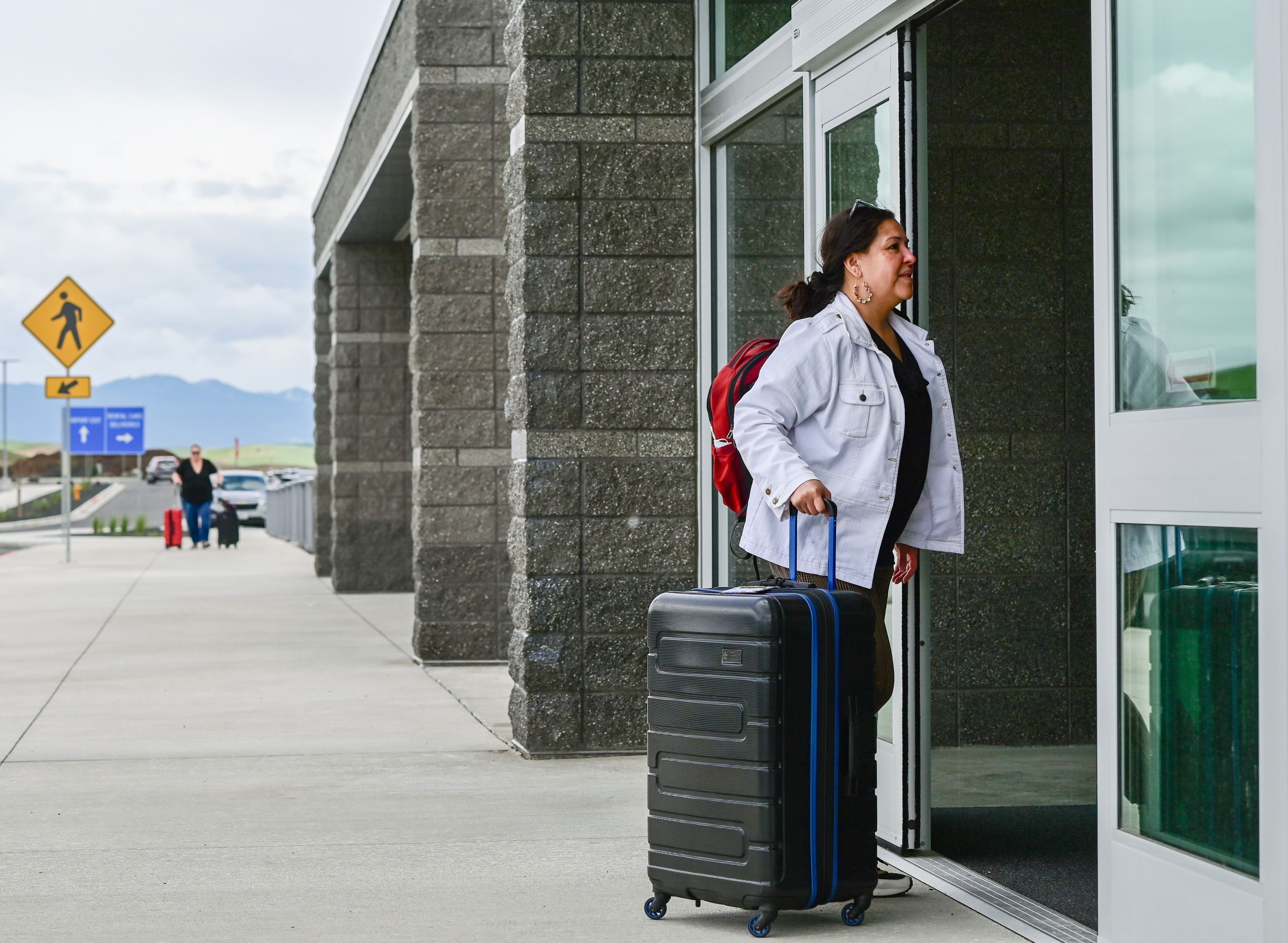 Lucila Loera, of Pullman, walks through the main doors of the new Pullman-Moscow Regional Airport terminal for a departing flight to Seattle on Wednesday.