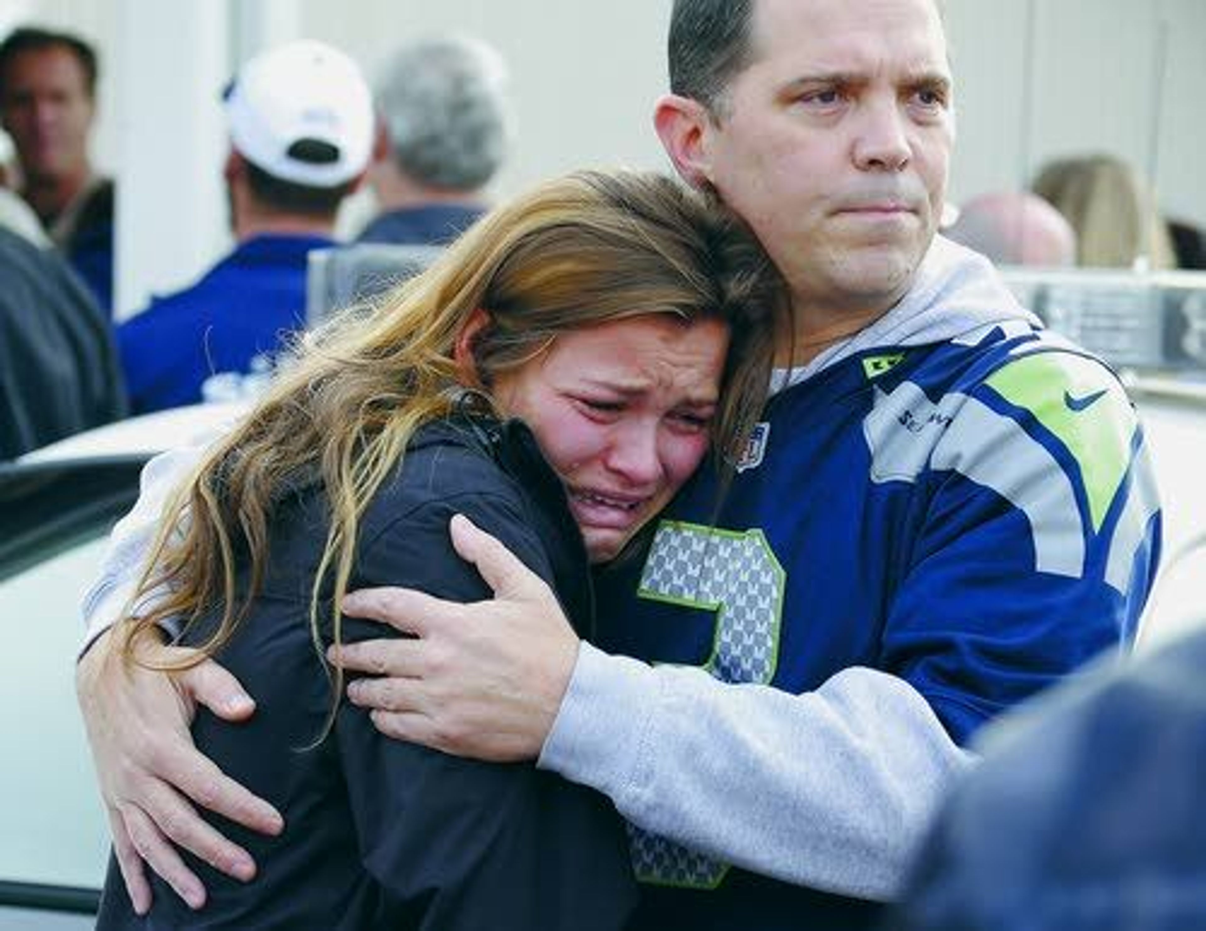 People react Friday as they wait at a church where students were taken to be reunited with parents following a school shooting in Marysville, Wash.