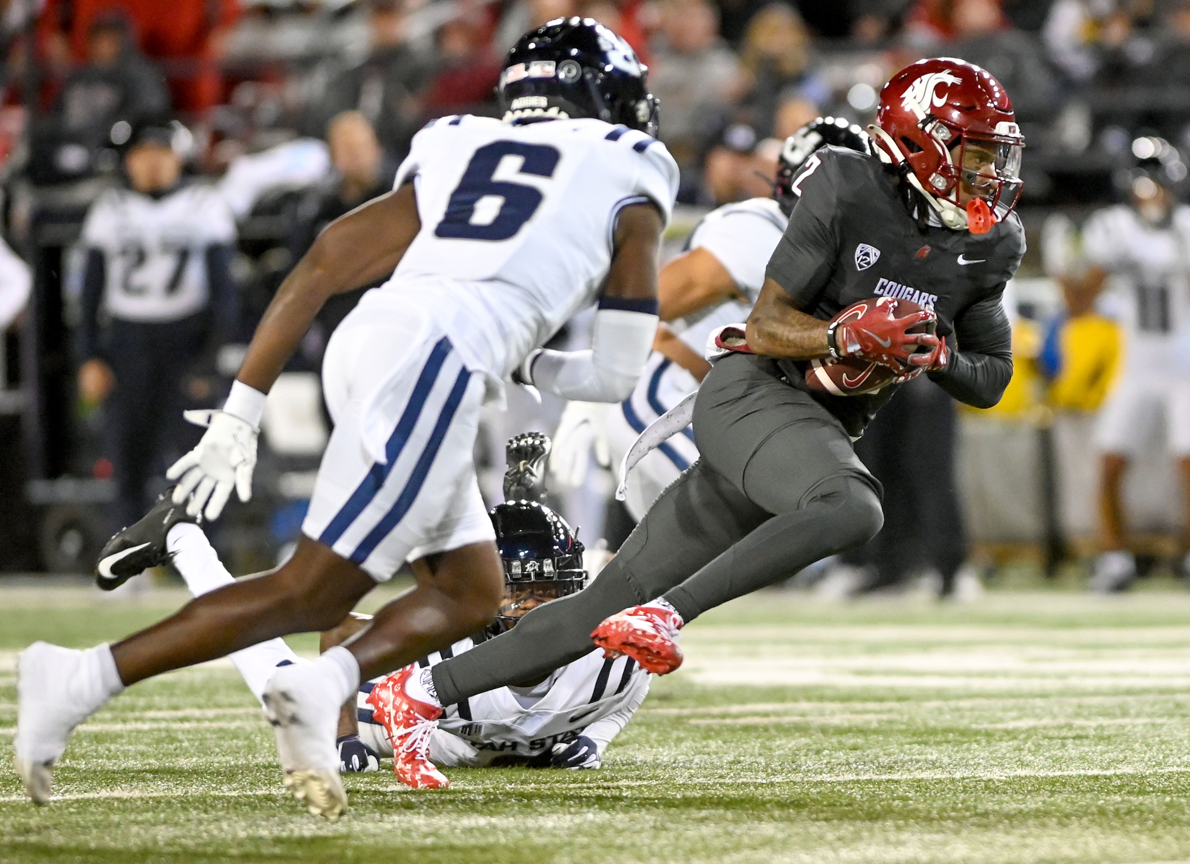 Washington State wide receiver Kyle Williams (2) out runs Utah State defenders Saturday at Gesa Field in Pullman. Williams carried the ball into the end zone for a touchdown.