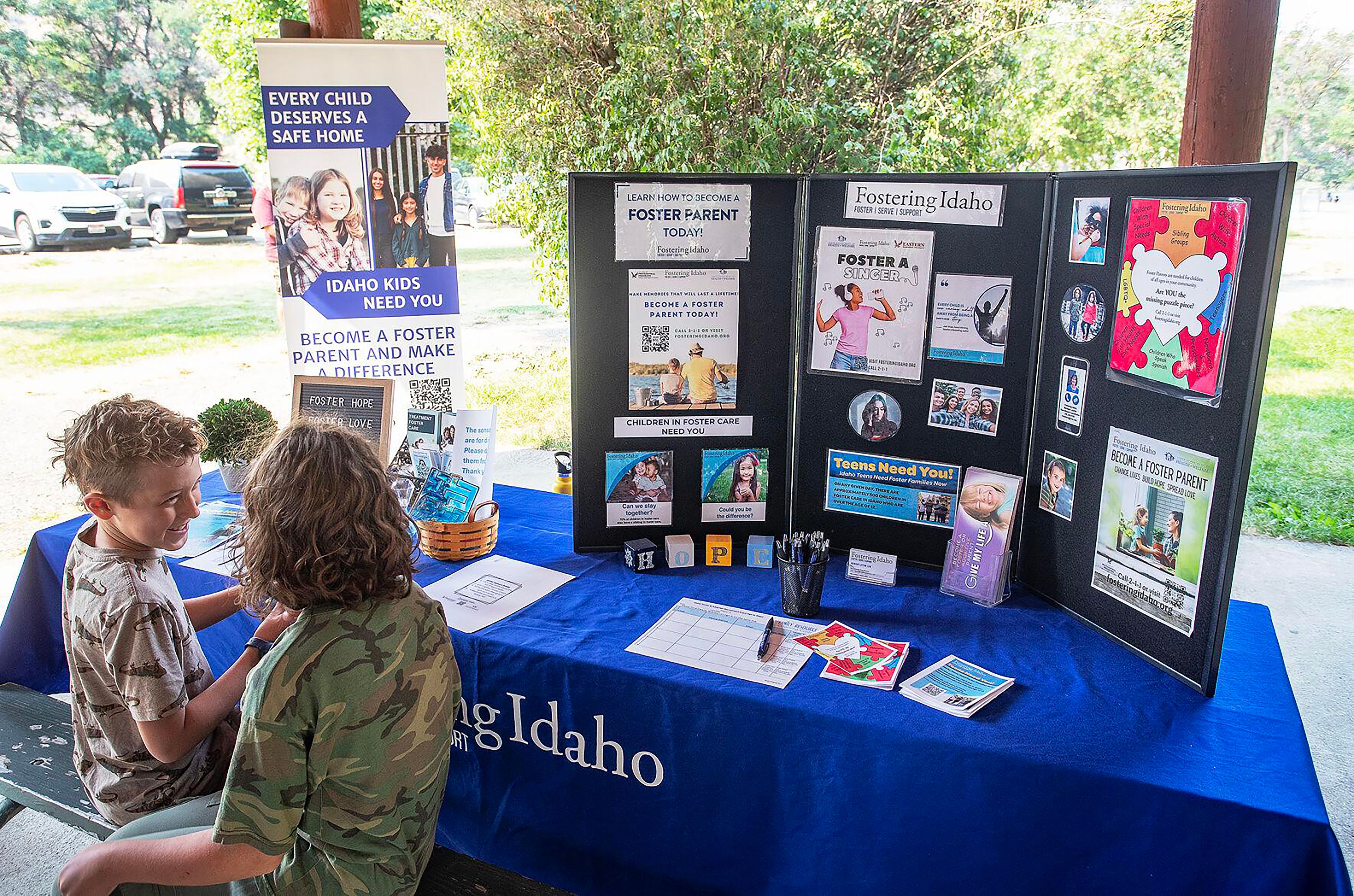 Children gather Wednesday at a display offering information on foster parenting during an event announcing the creation of the Idaho State Park Foster Family Passport program.