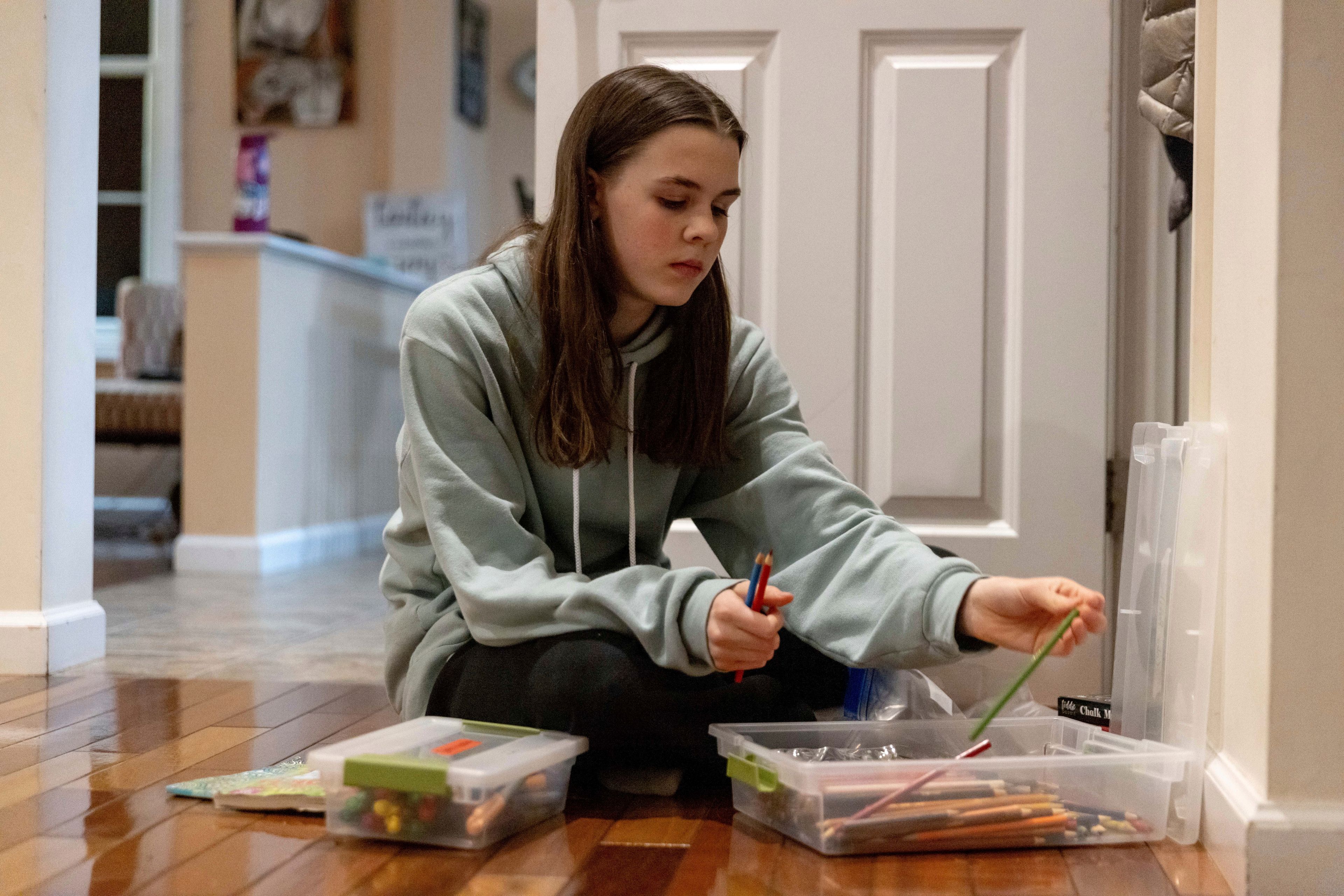 Sutton Bulkeley packs art materials ahead of a ski vacation, Friday, Feb. 16, 2024, in Westport, Conn. It is hard to be a teenager today without social media. For those trying to stay off social platforms at a time when most of their peers are immersed, the path can be challenging, isolating and at times liberating. It can also be life-changing.