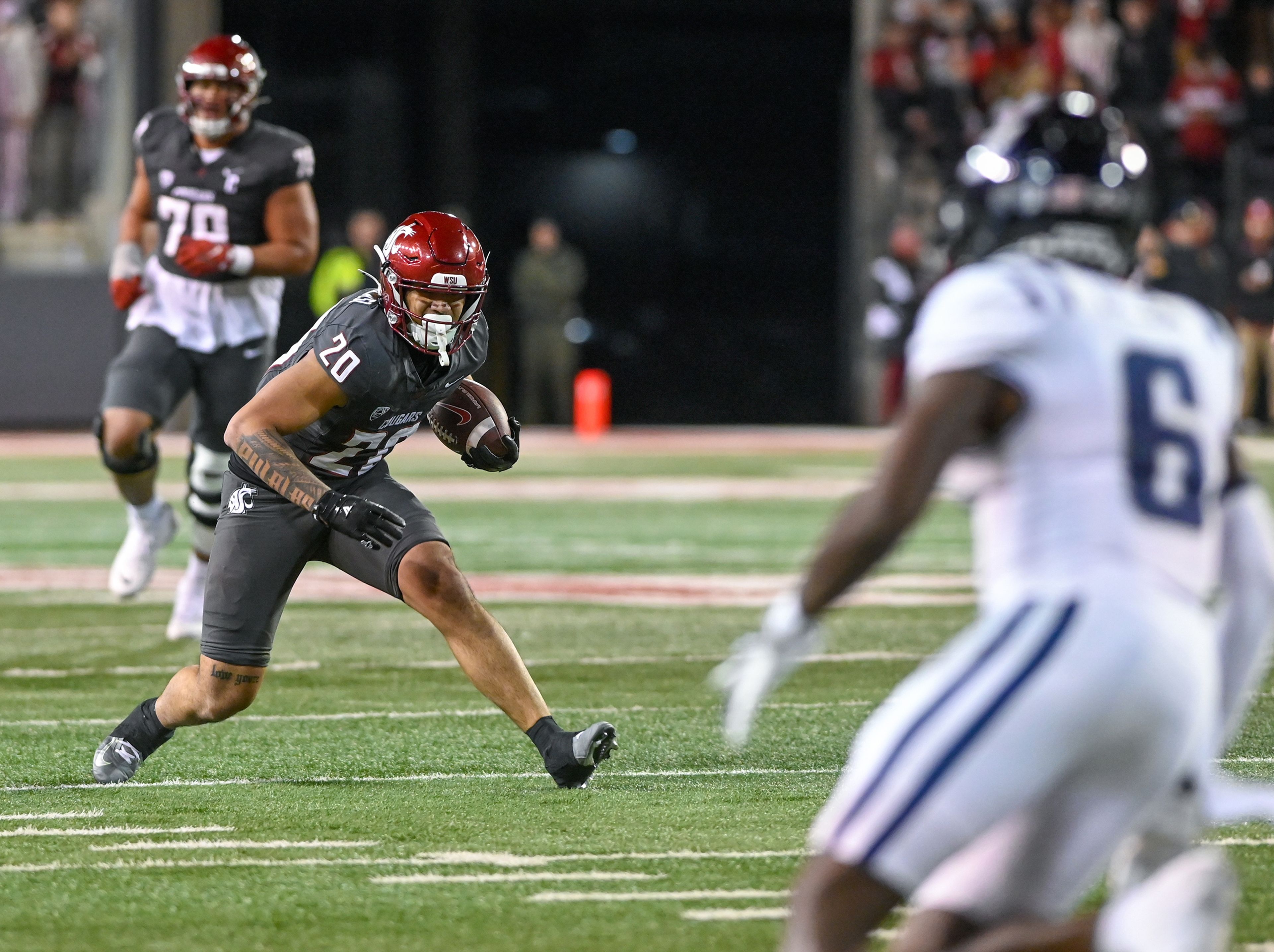 Washington State running back Leo Pulalasi (20) turns after catching the ball to look for an opening in Utah State defense Saturday at Gesa Field in Pullman.