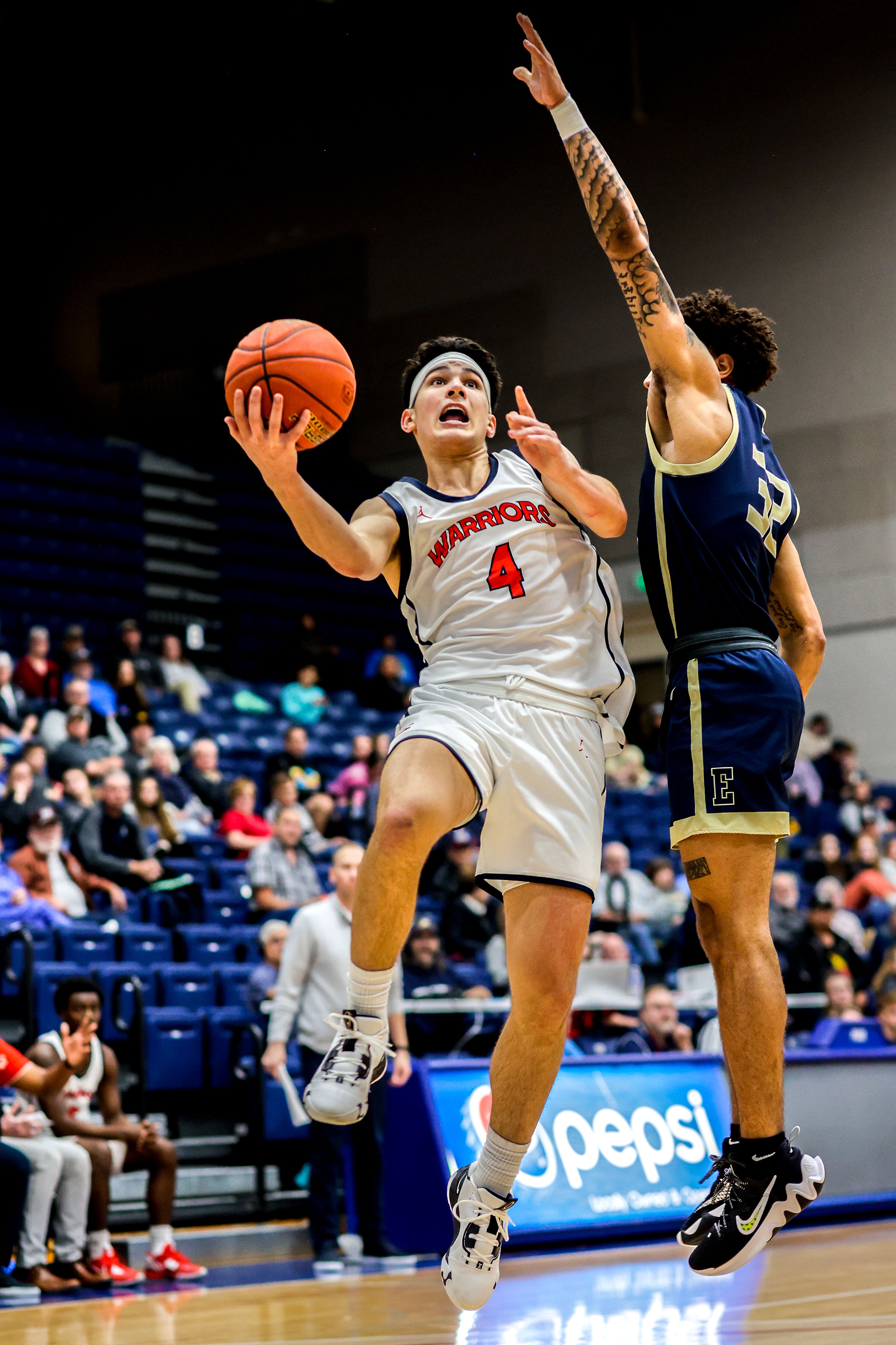 Lewis-Clark State guard Silas Bennion, left, shoots as Eastern Oregon guard Andre Huddlestonk guards him during a Cascade Conference game Friday at Lewis-Clark State College.