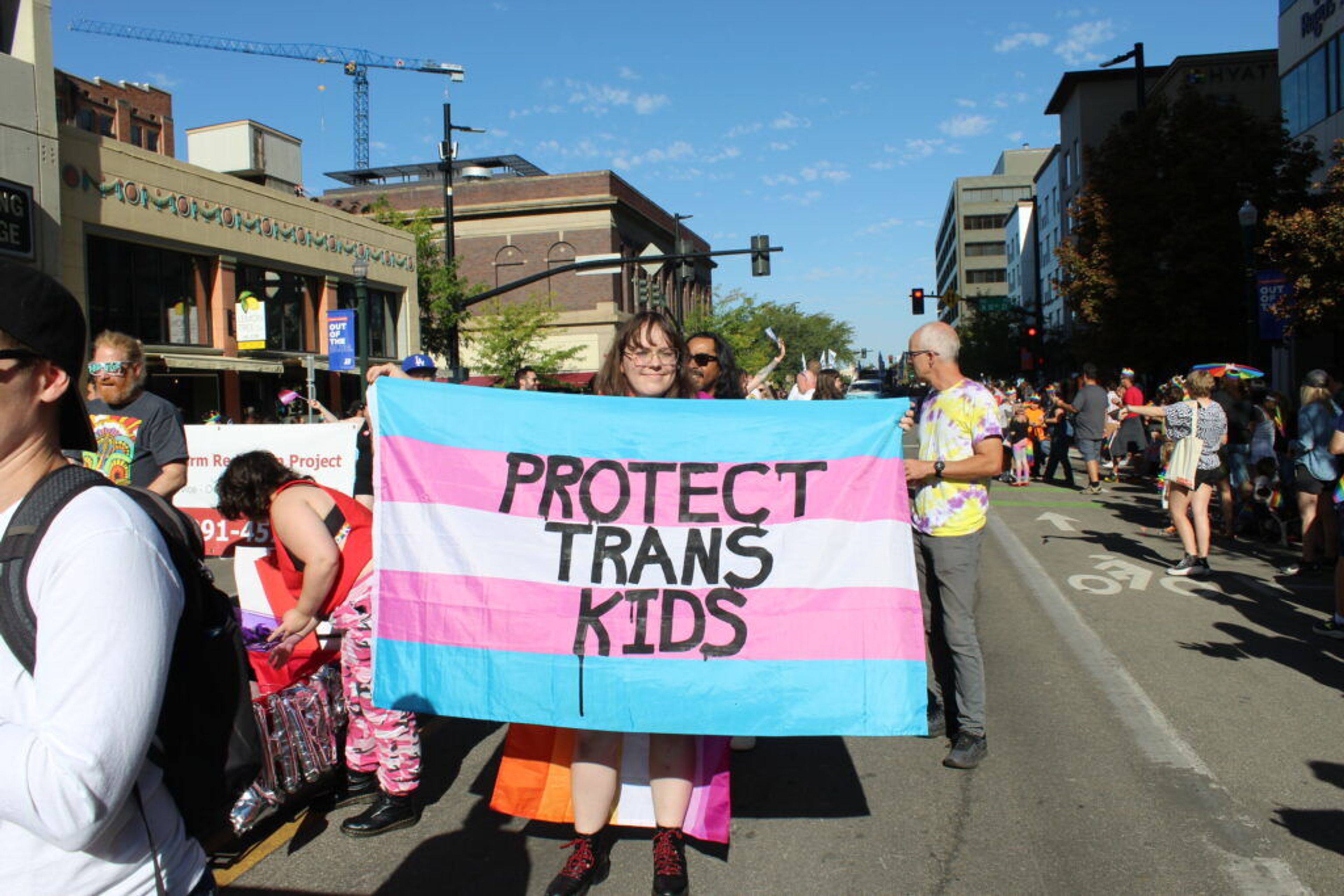 A participant in the Boise Pride parade in September holds a banner supporting transgender youth.