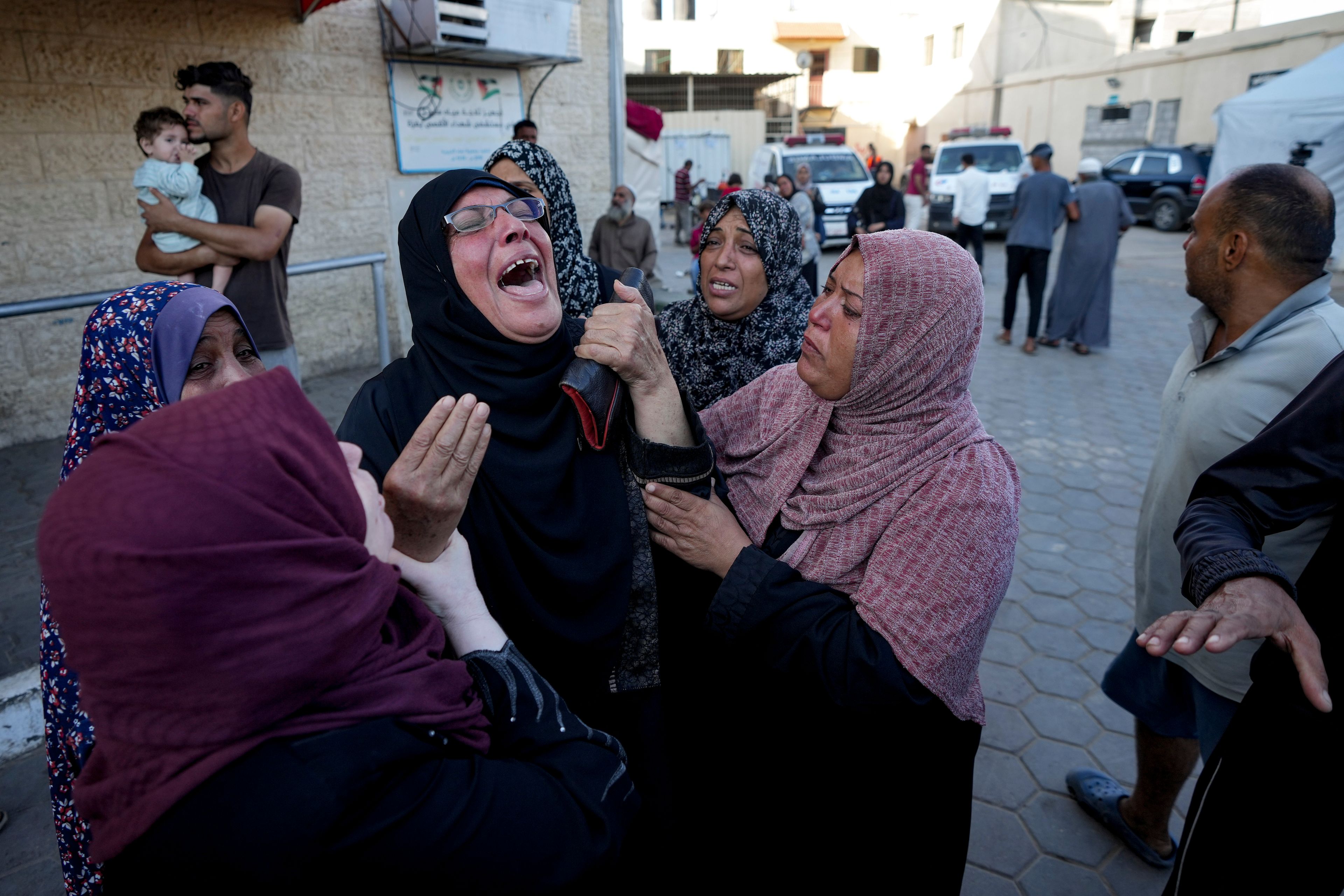 Palestinians mourn for relatives killed in the Israeli bombardment of the Gaza Strip at a hospital morgue in Deir al-Balah, Wednesday, Oct. 2, 2024. (AP Photo/Abdel Kareem Hana)